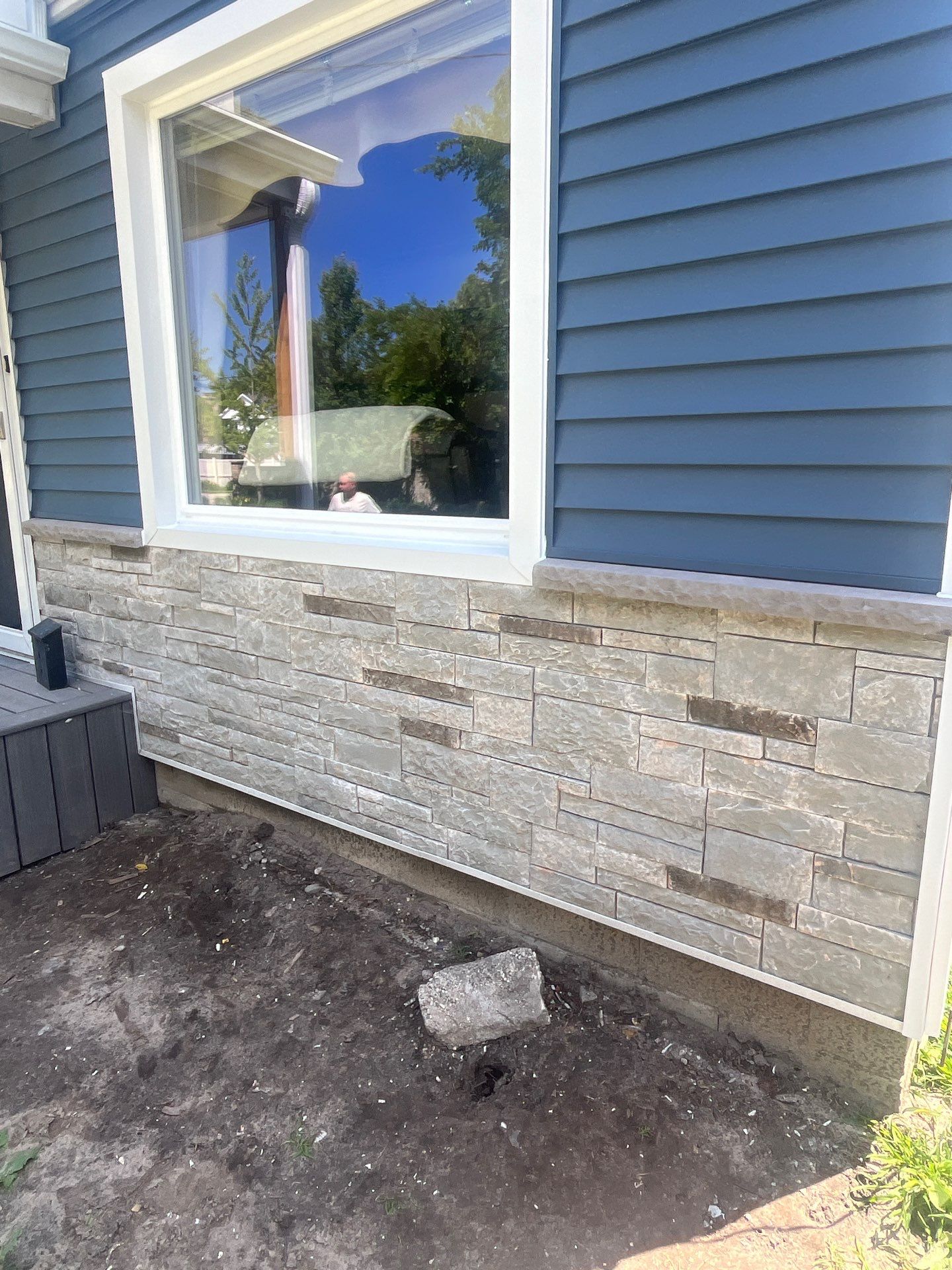 Blue Vinyl Siding and Versetta Stone Exterior Remodel in Bay City by Great Lakes Home Design LLC