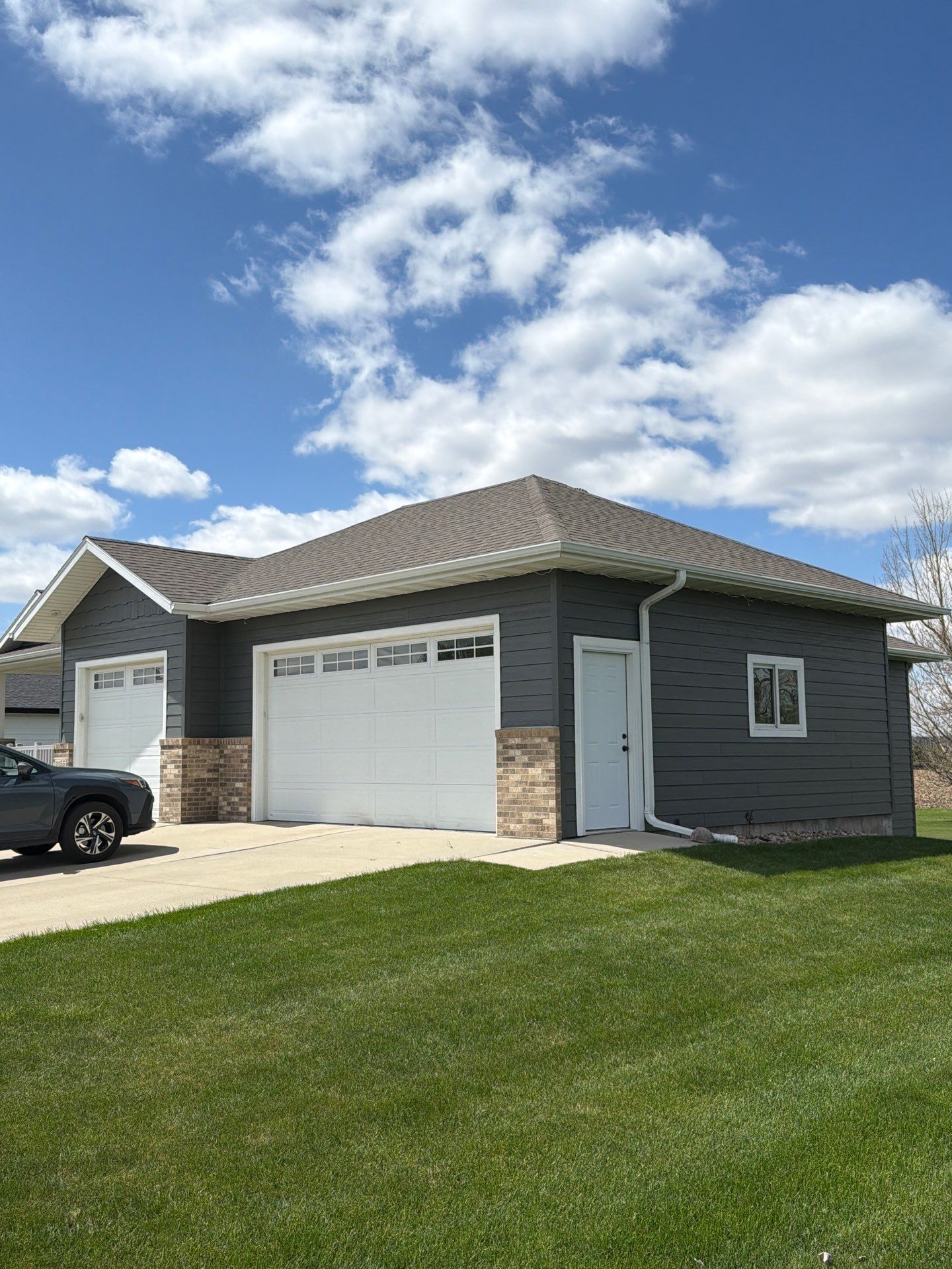 Madison Exterior Remodel with Dark Gray Siding and Stone Accents by Select Painting, Coatings & Garage Cabinets
