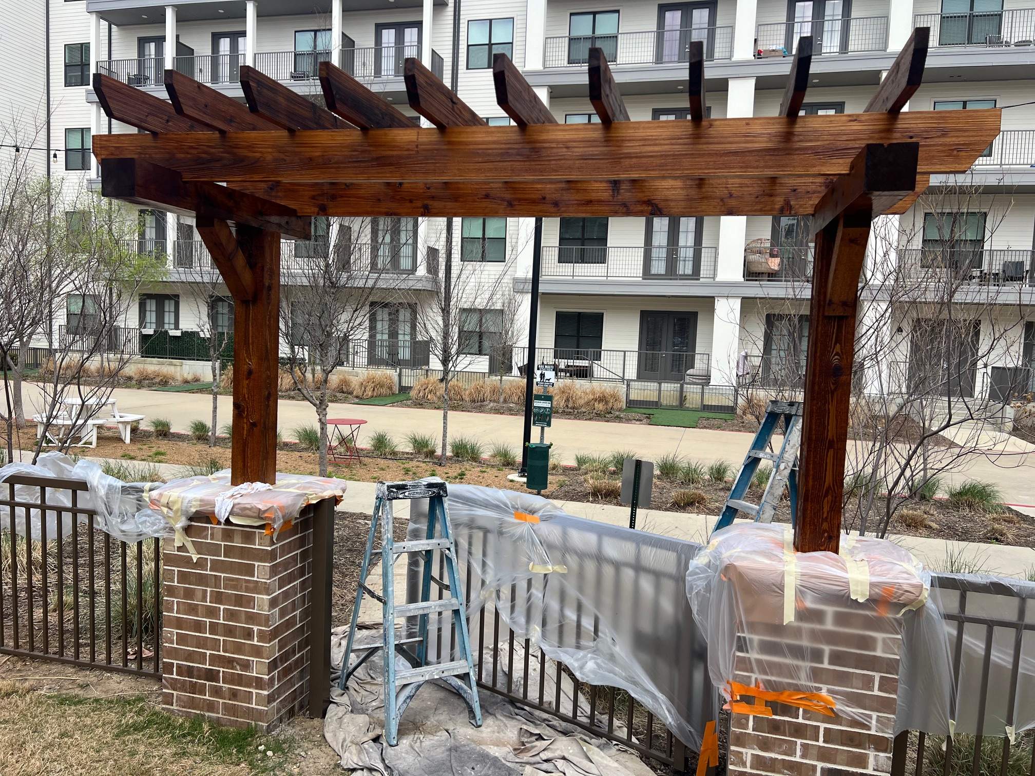 Arbor with Wrought Iron Fencing by 3:16 Roofing and Construction