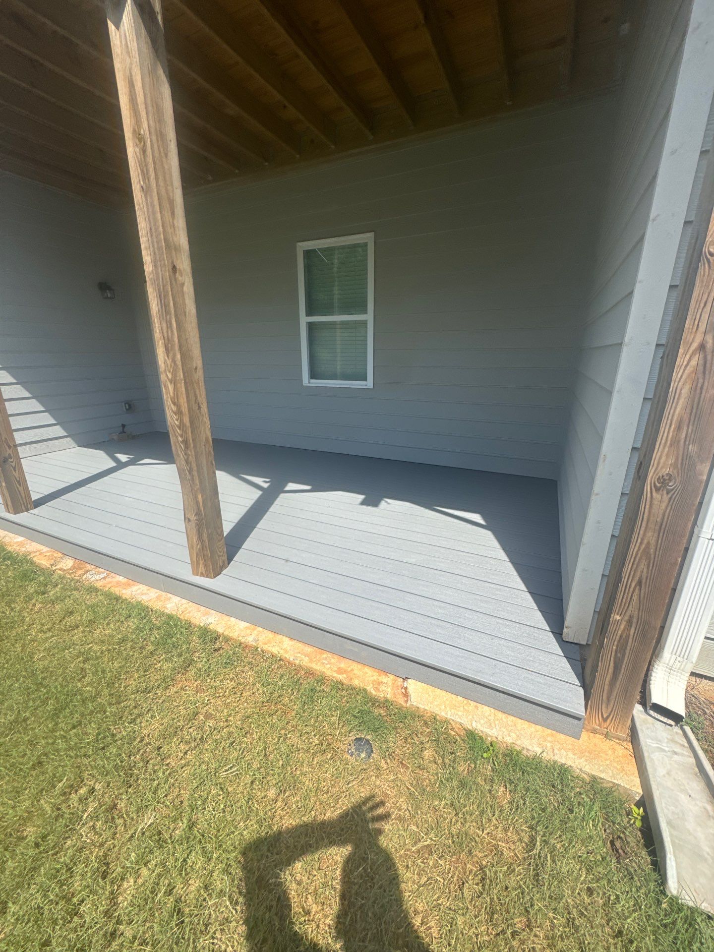 Ground-Level Gray Composite Deck and Privacy Fence Installation by Swift Home Renovations