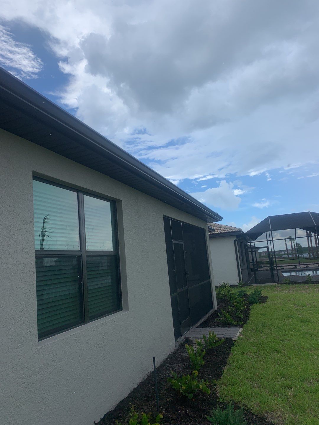 Seamless brown gutter and downspouts installation in Estero, FL  by Gutter Professors