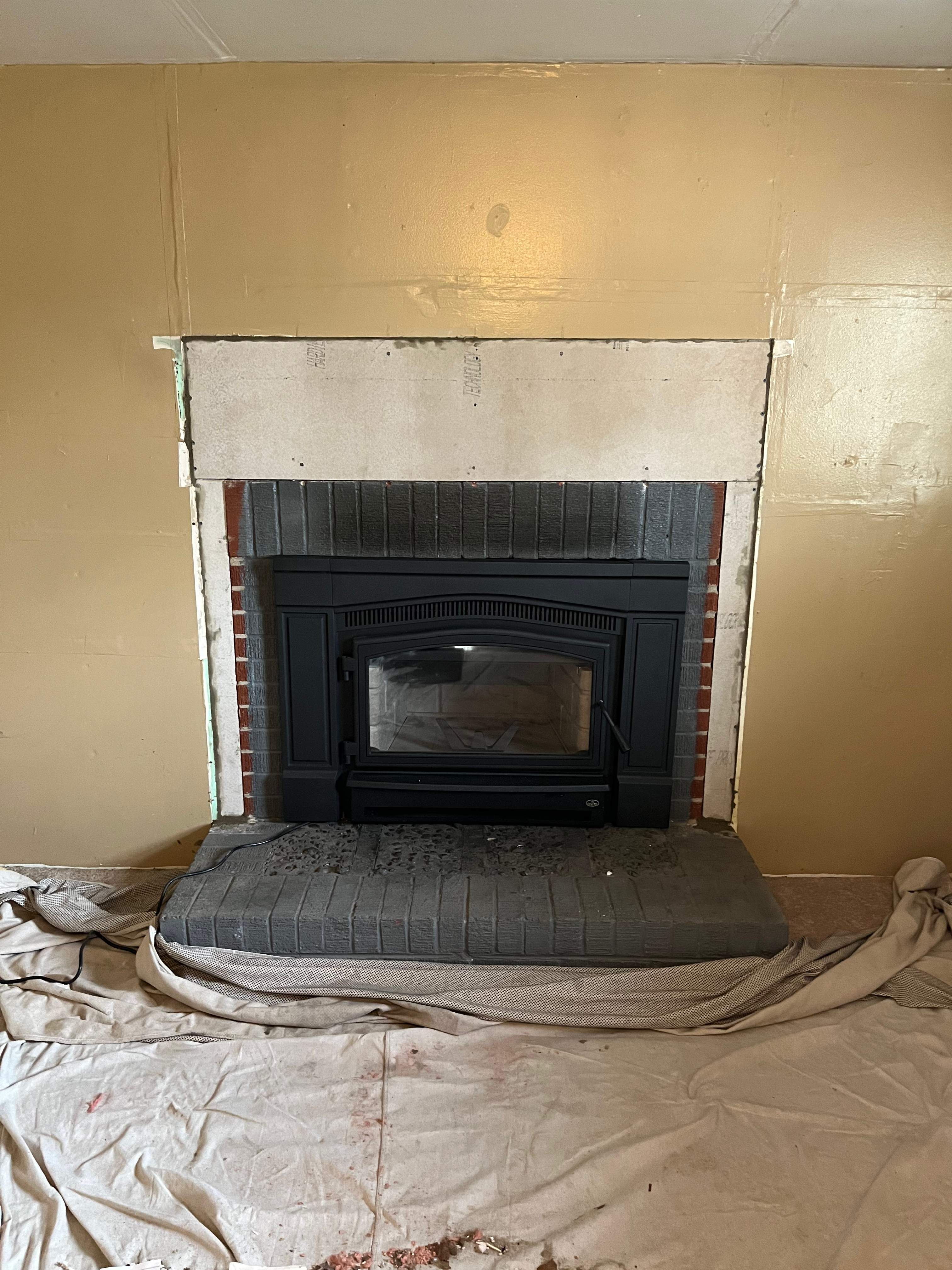 Wood Stove Insert + Stone + Mantel by Premier Chimney and Roofing