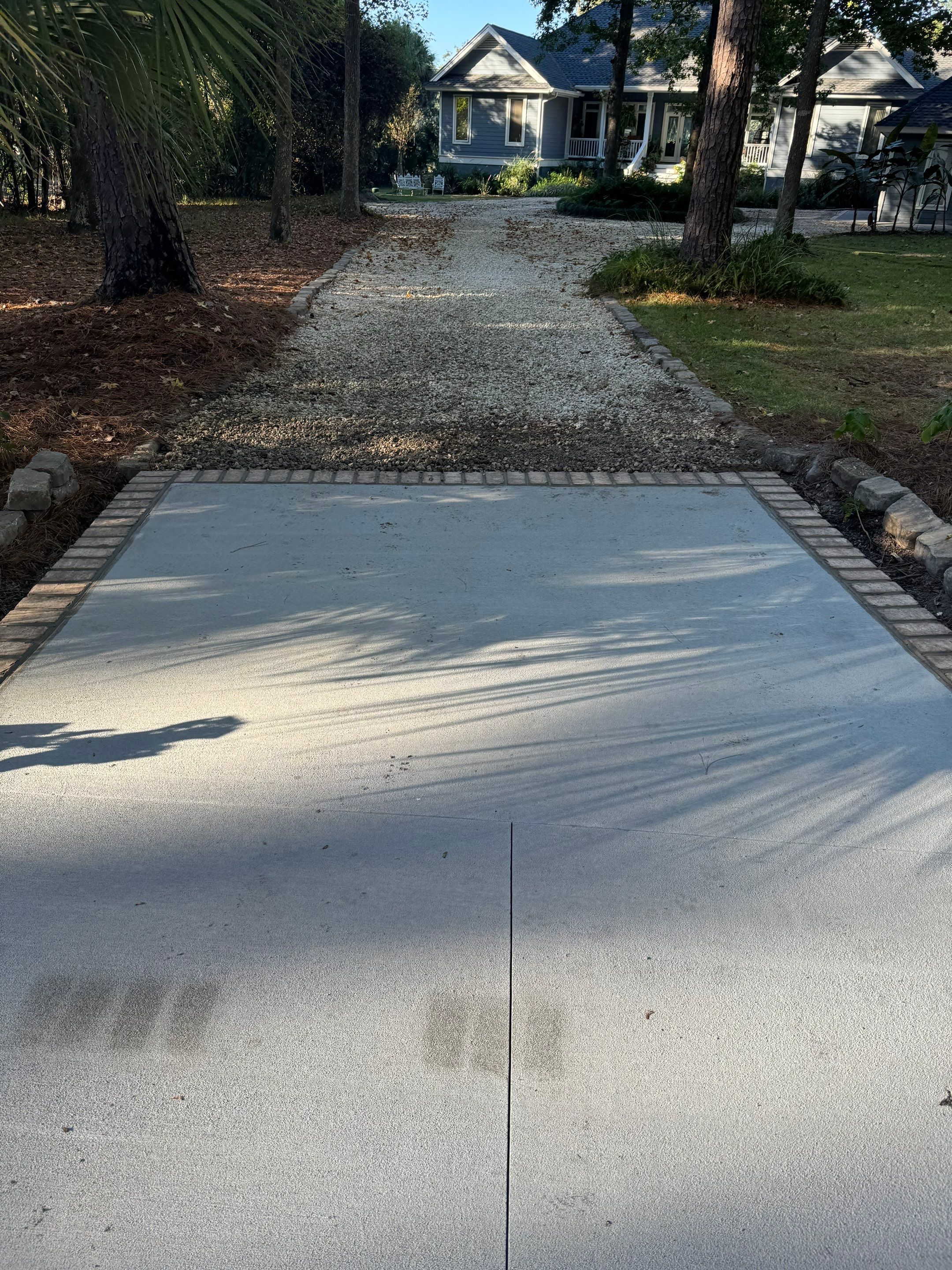 Concrete Driveway and Patio Installation With Decorative Brick Borders by Lowcountry Scapes, LLC