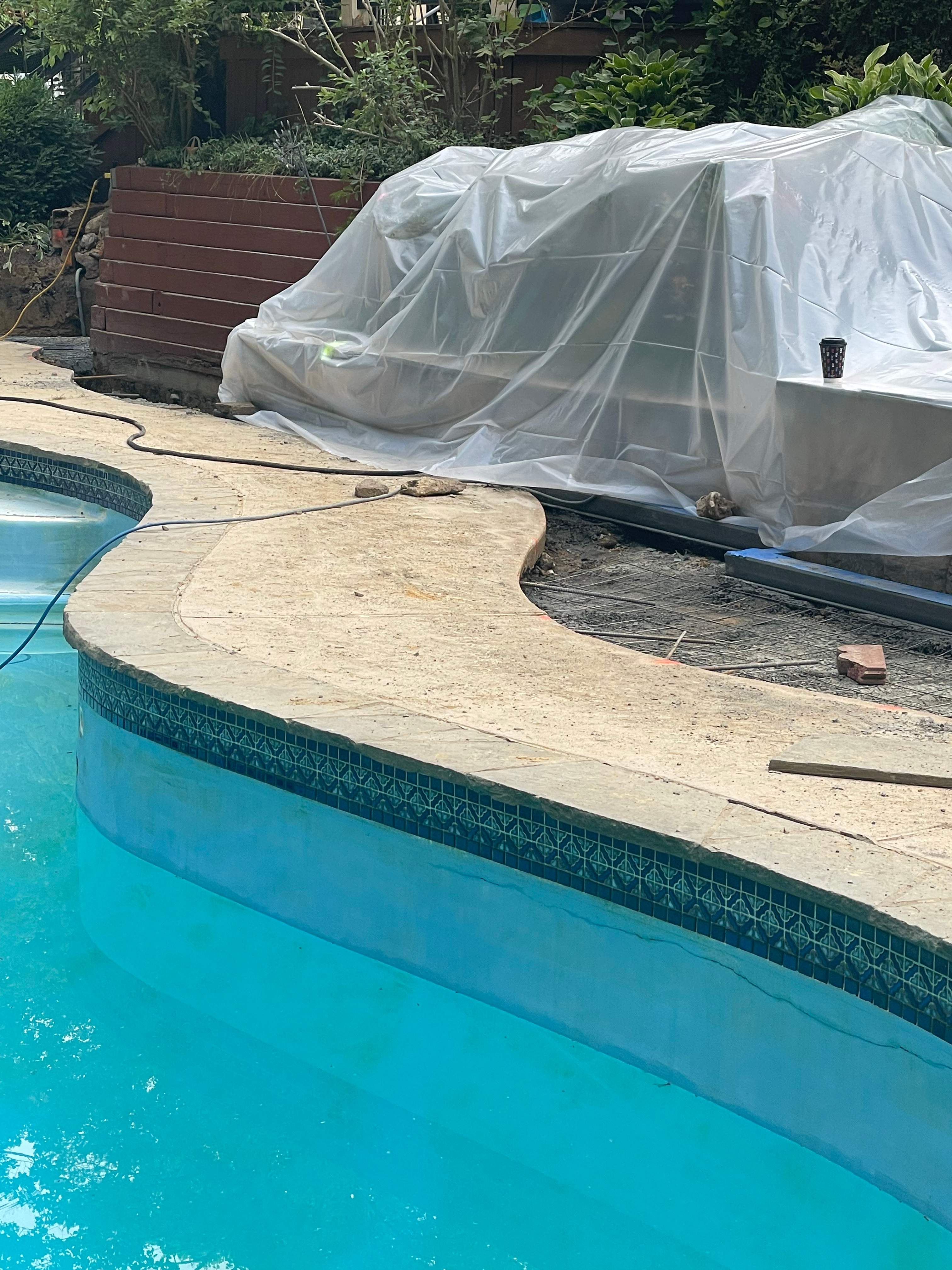 Pool Surround remodel with retaining walls, new waterfall and water slide by Fairfax Contractors, LLC