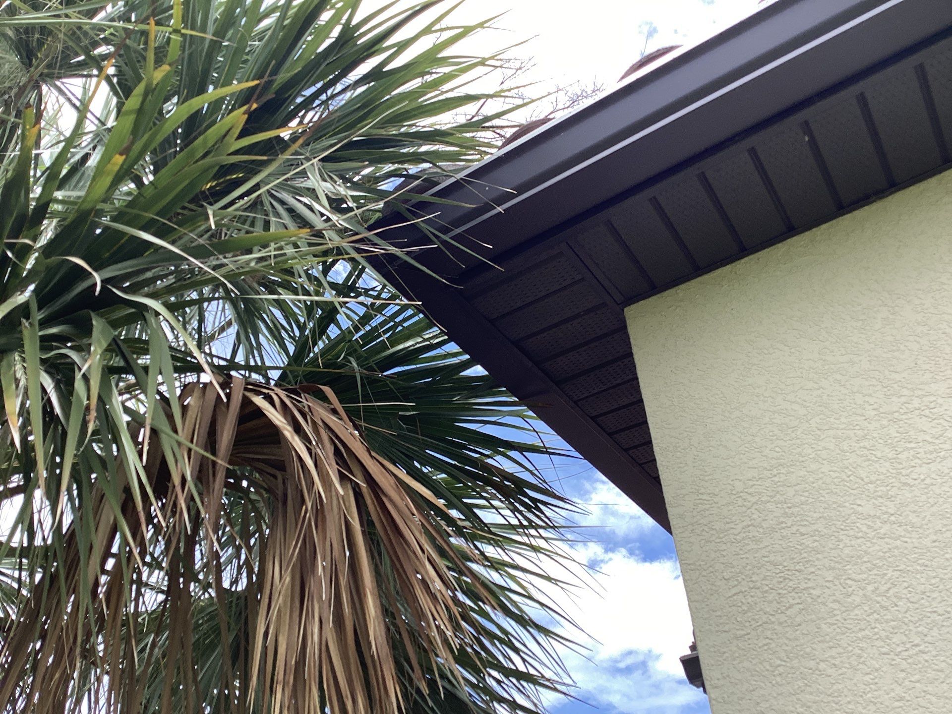 Musket brown seamless gutters with splash guards, new downspouts, and extensions in Bradenton, FL by Gutter Professors
