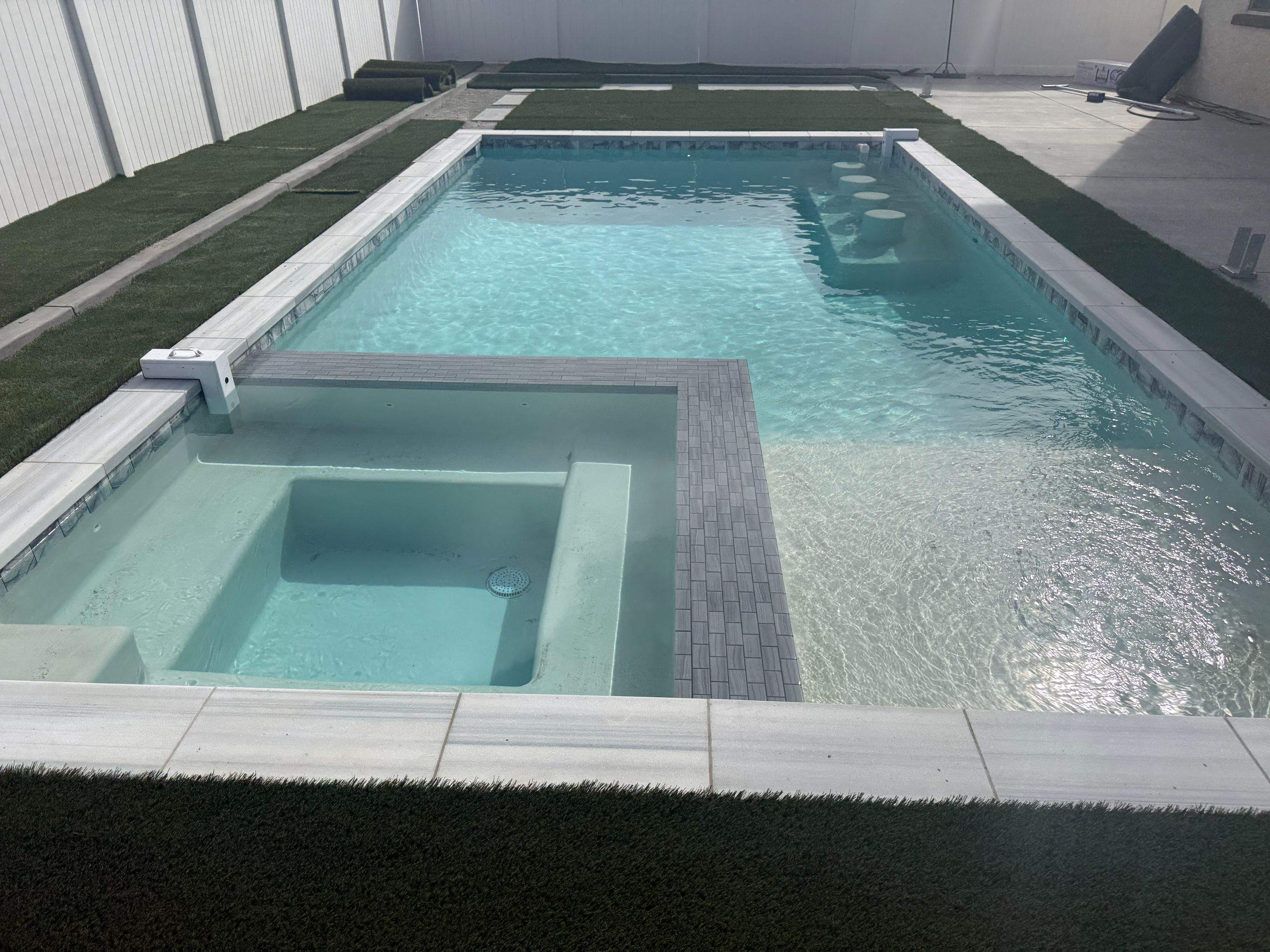 Pool and spa modern shape turf around pool by Premier Pools and Spas Temecula