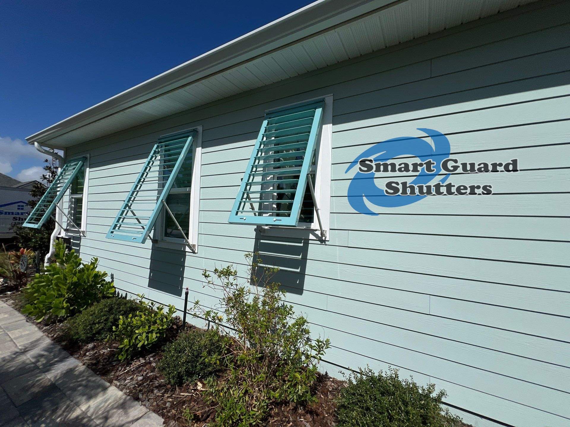 Impact Bahama Shutters in Pastel Turquoise by Smart Guard Shutters