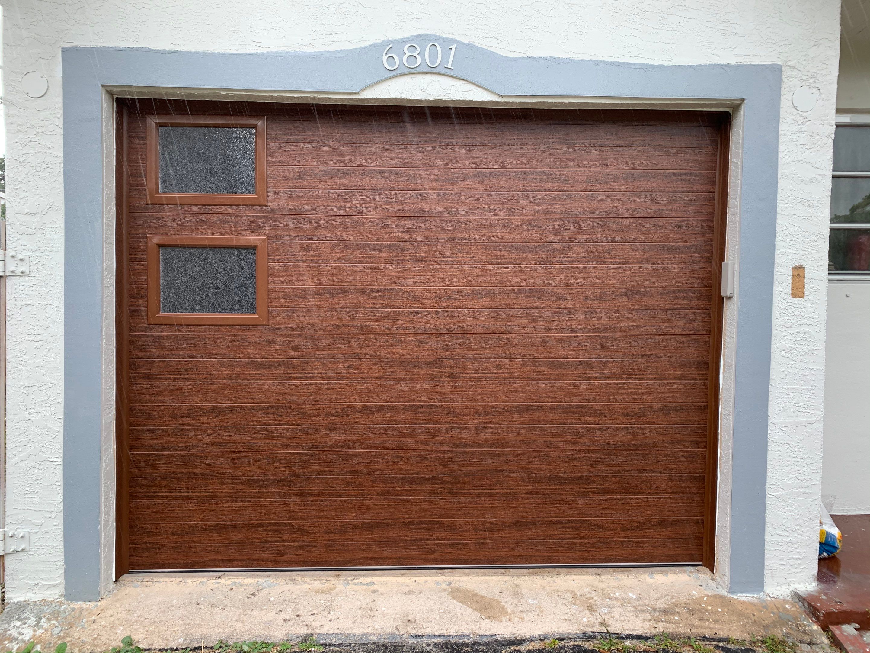 Sectional Garage Door Installation with Wood-Grain Finish in Sunrise - Clopay Modern Steel