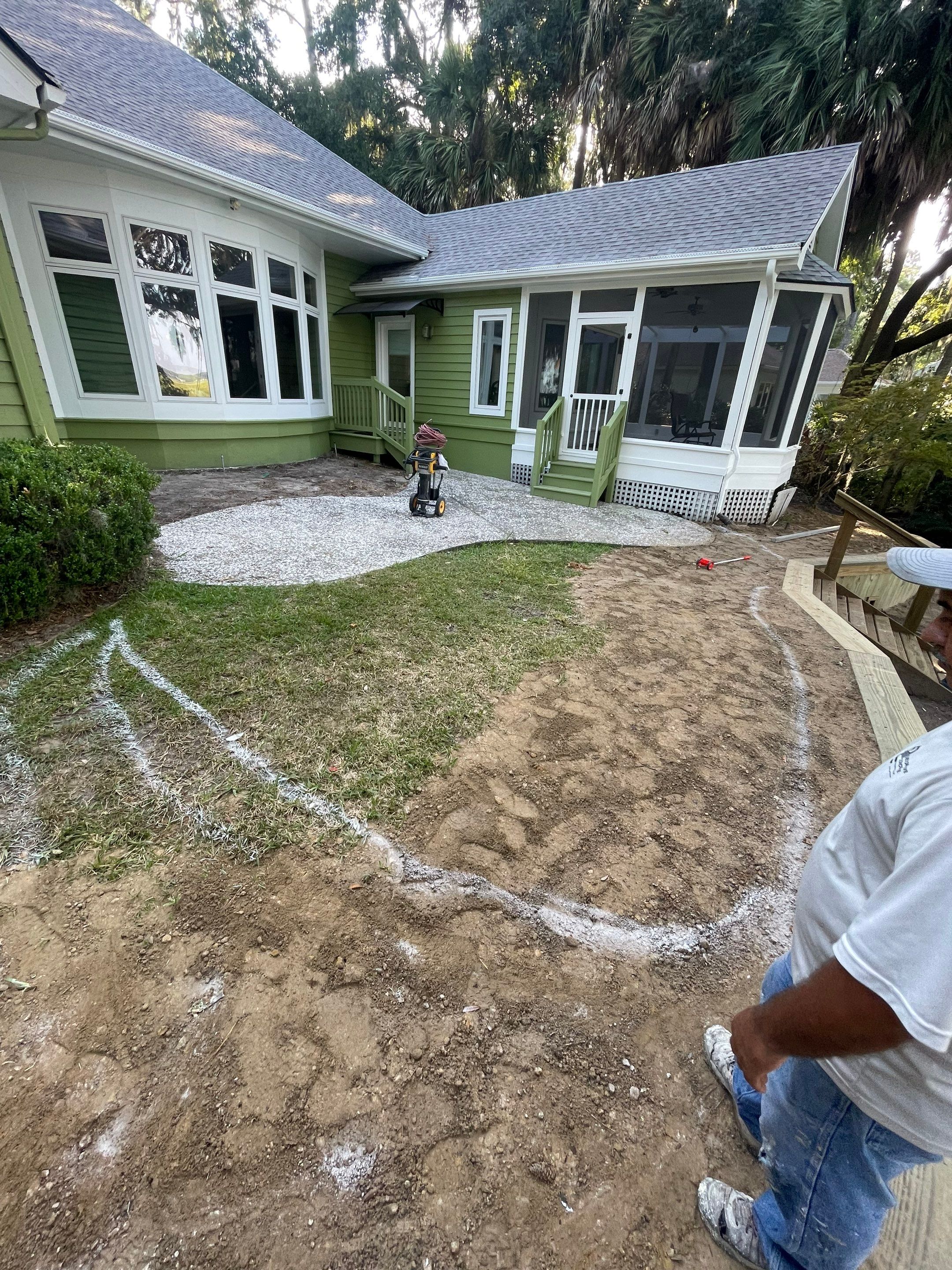 Exposed Aggregate Patio with Brick Inlays and Retaining Wall in Okatie by Lowcountry Scapes, LLC