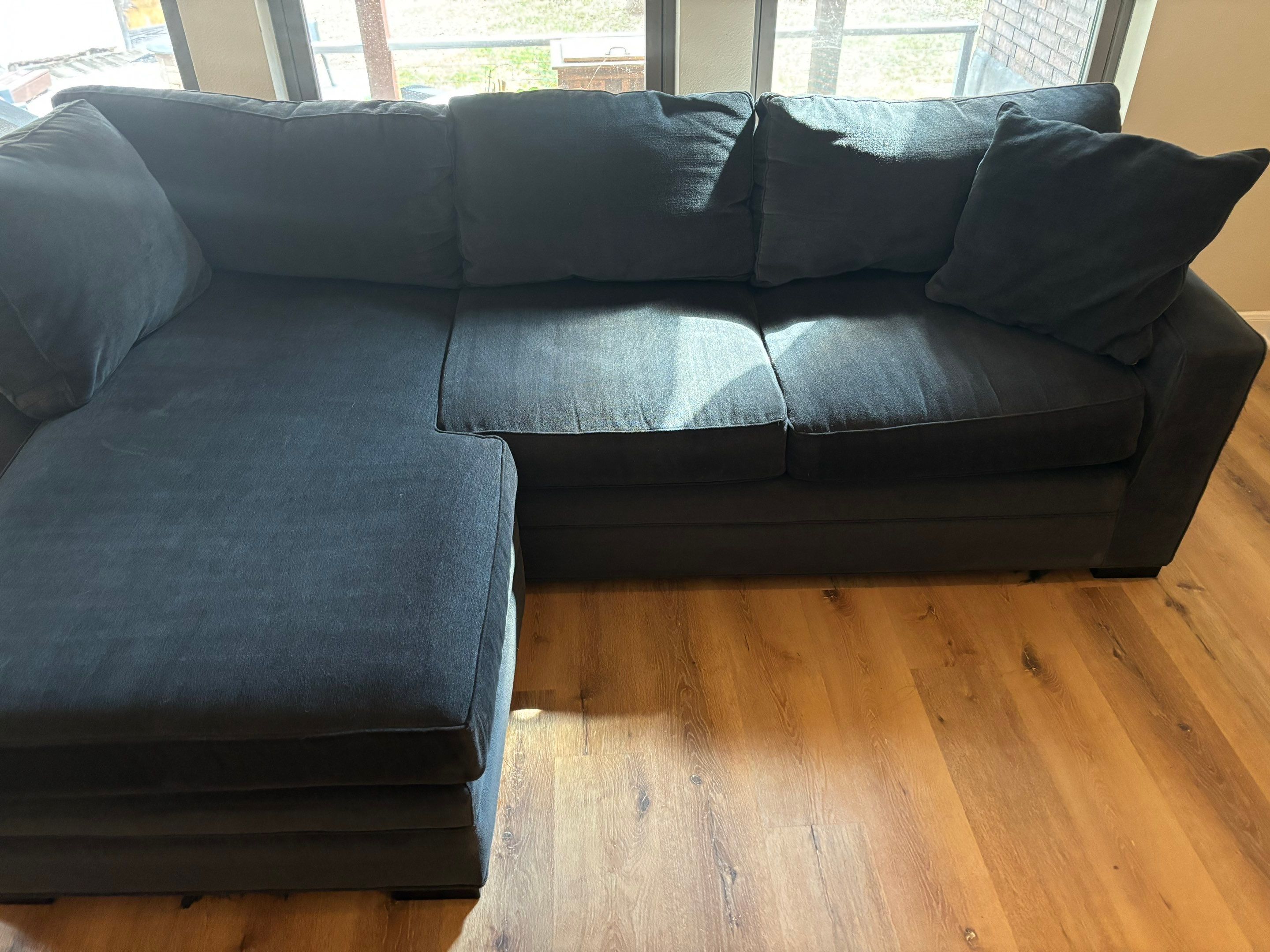 the service shown is upholstery cleaning for a dark fabric couch located on wood flooring