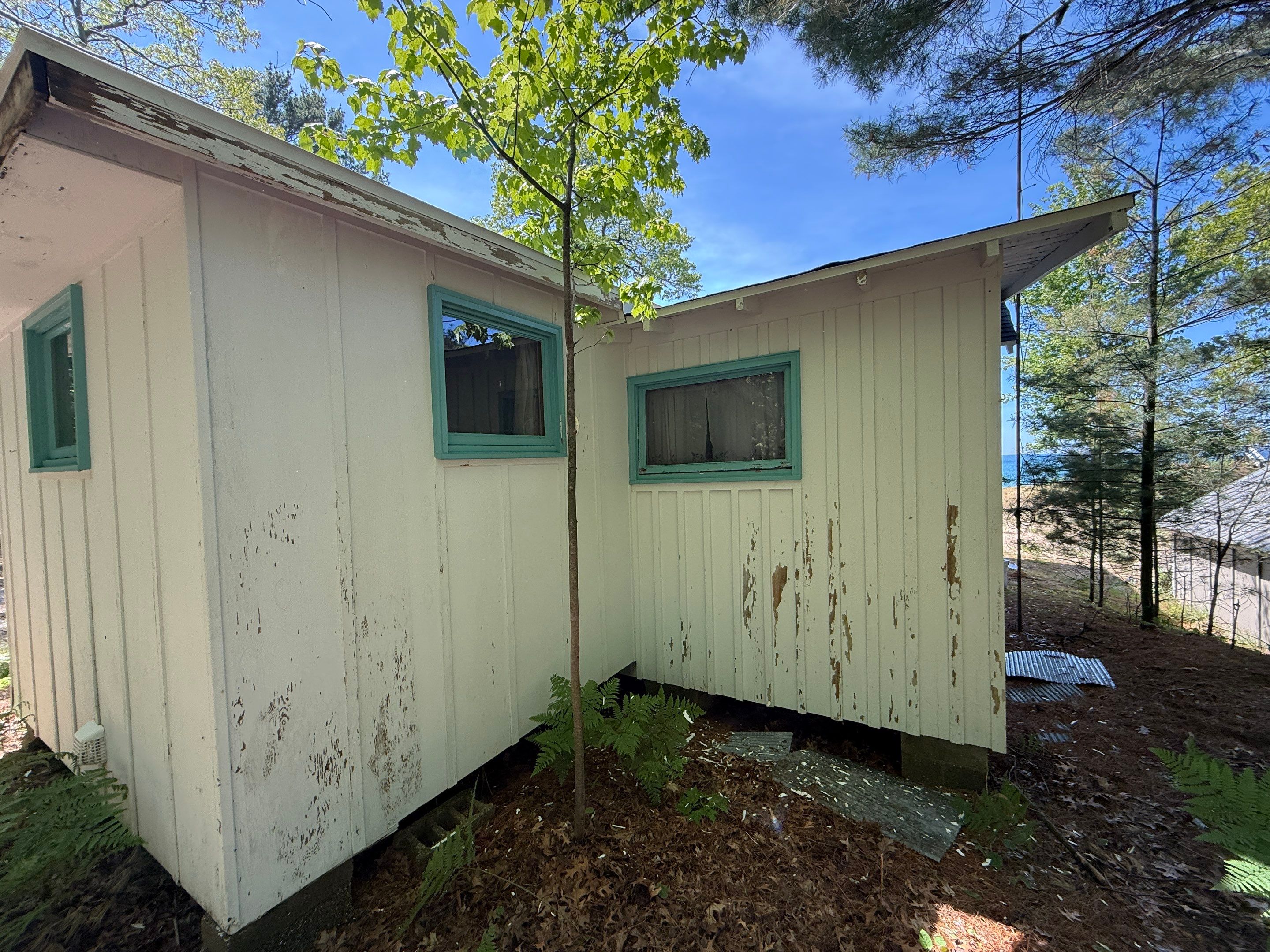 Lakeside Cottage Exterior Painting and Teal Trim Restoration in Mears by Gordon Painting