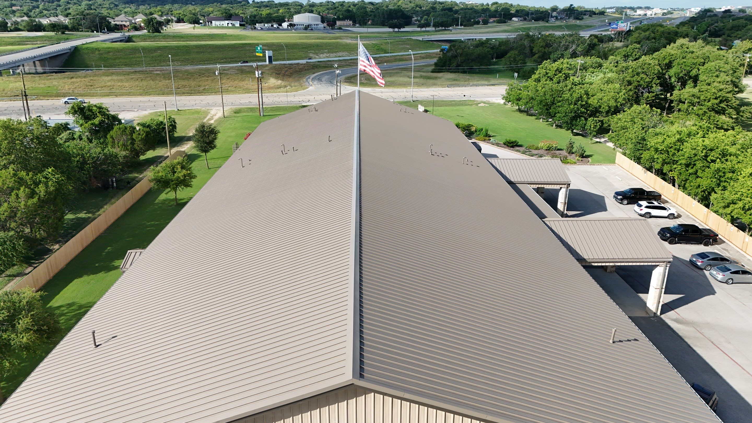 Commercial Roofing Installation using  24 GA 2" Seam Metal Retrofin - Buckskin by Action Exteriors