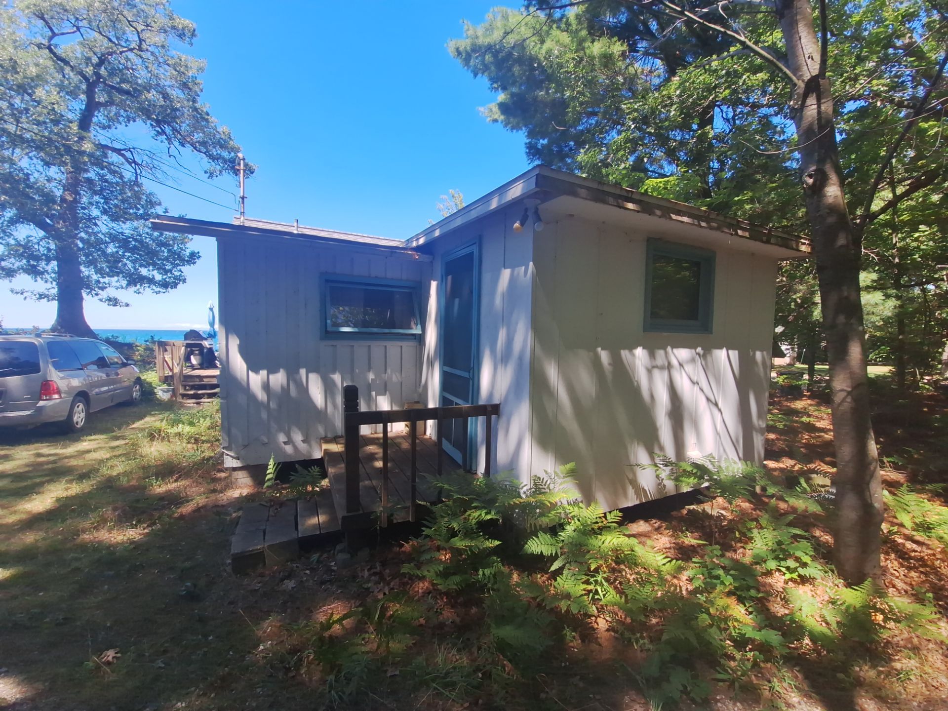 Lakeside Cottage Exterior Painting and Teal Trim Restoration in Mears by Gordon Painting