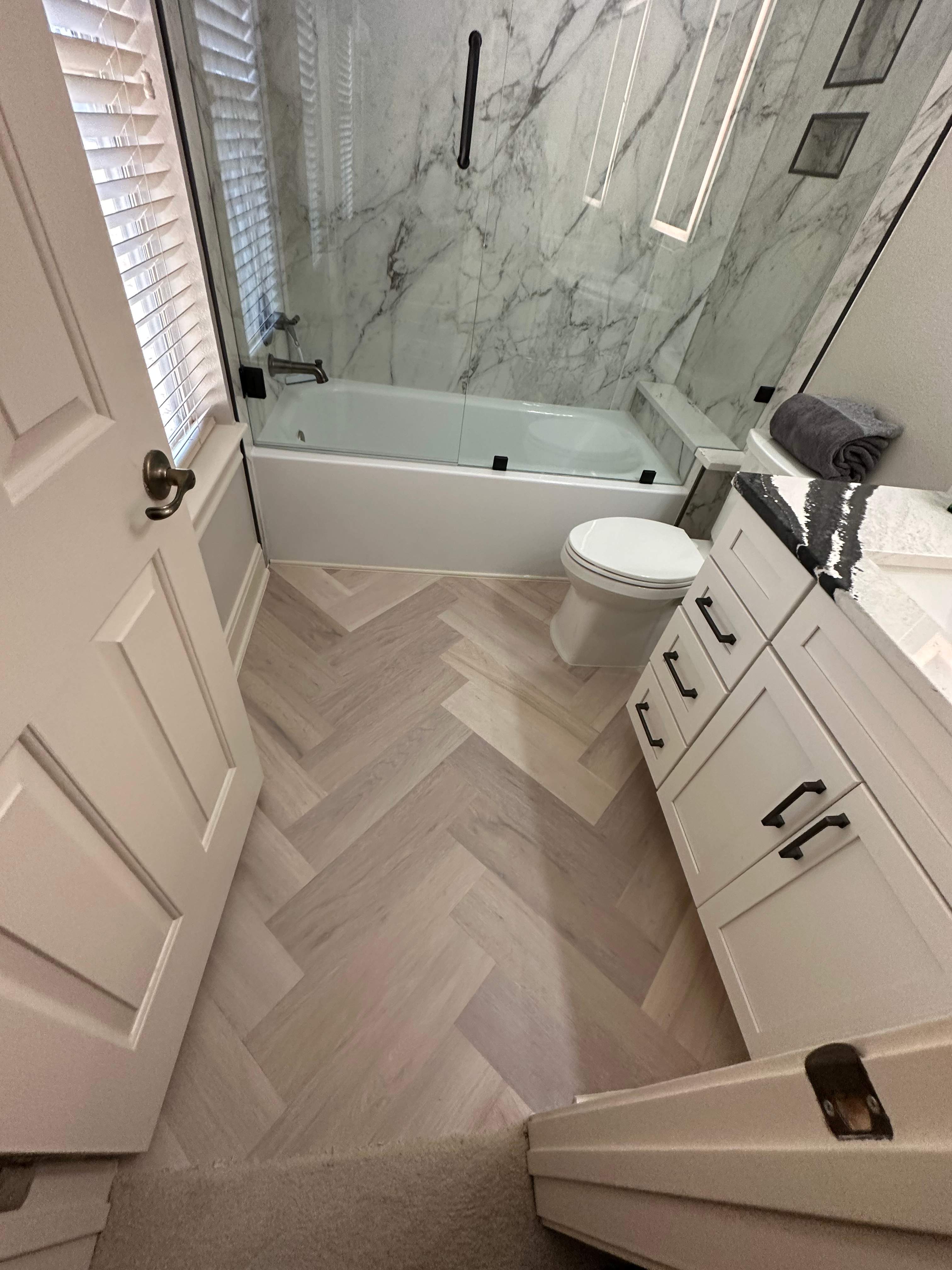 Boerne Guest Bathroom Remodel with Marble Tub Surround & Herringbone Flooring by Legacy Bath and Kitchen