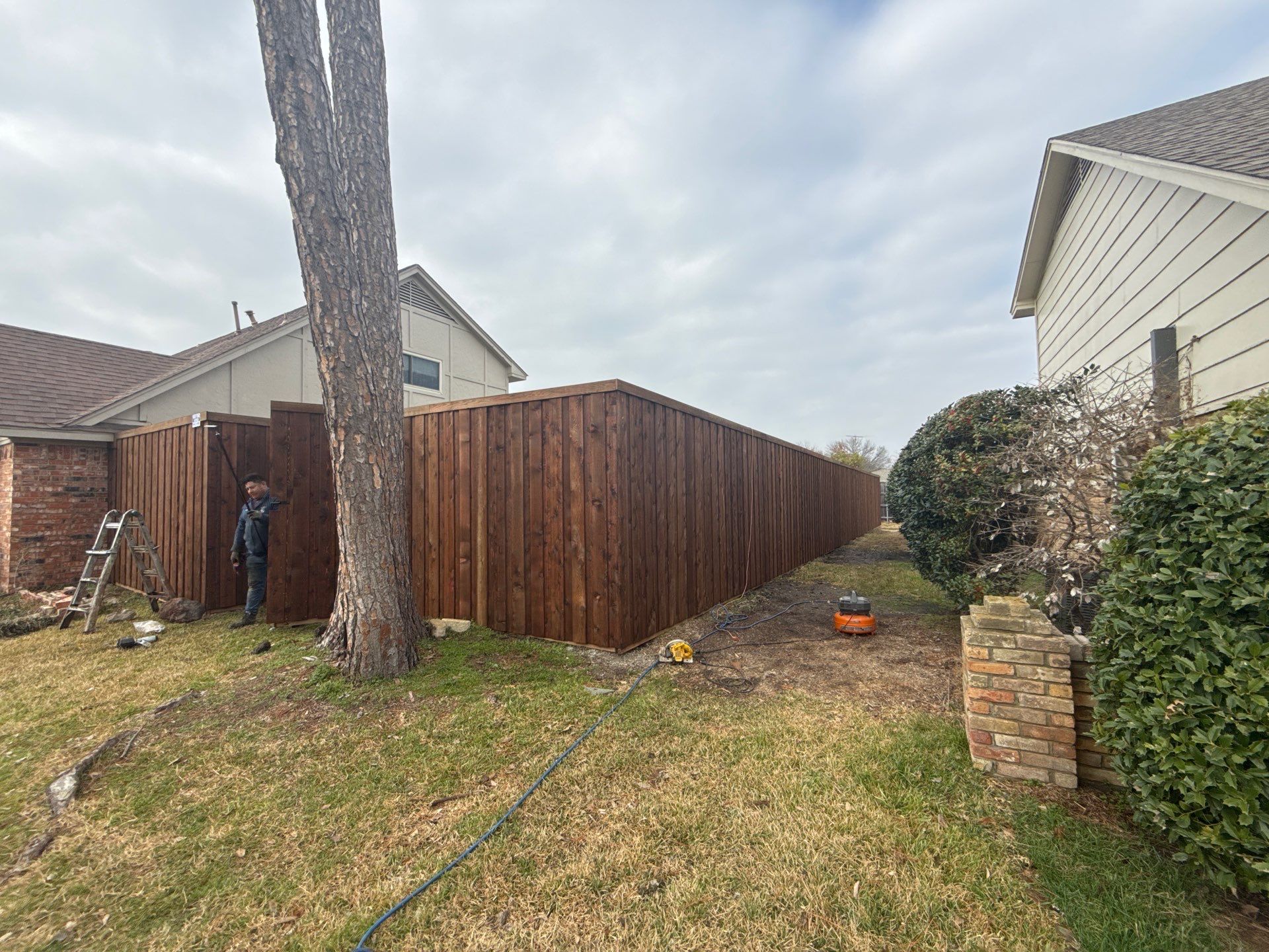 Pre-Stained board on board w/ trim and kickboard using 1x4 cedar trim by Grizzly Fence And Patio