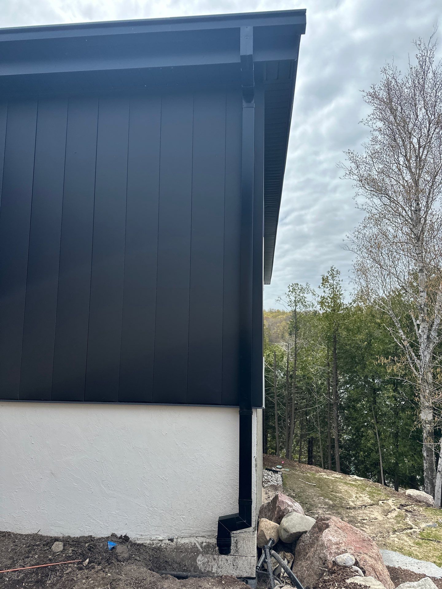 Matte Black Gutter and Downspout Installation in East Jordan by Rainbow Seamless Systems