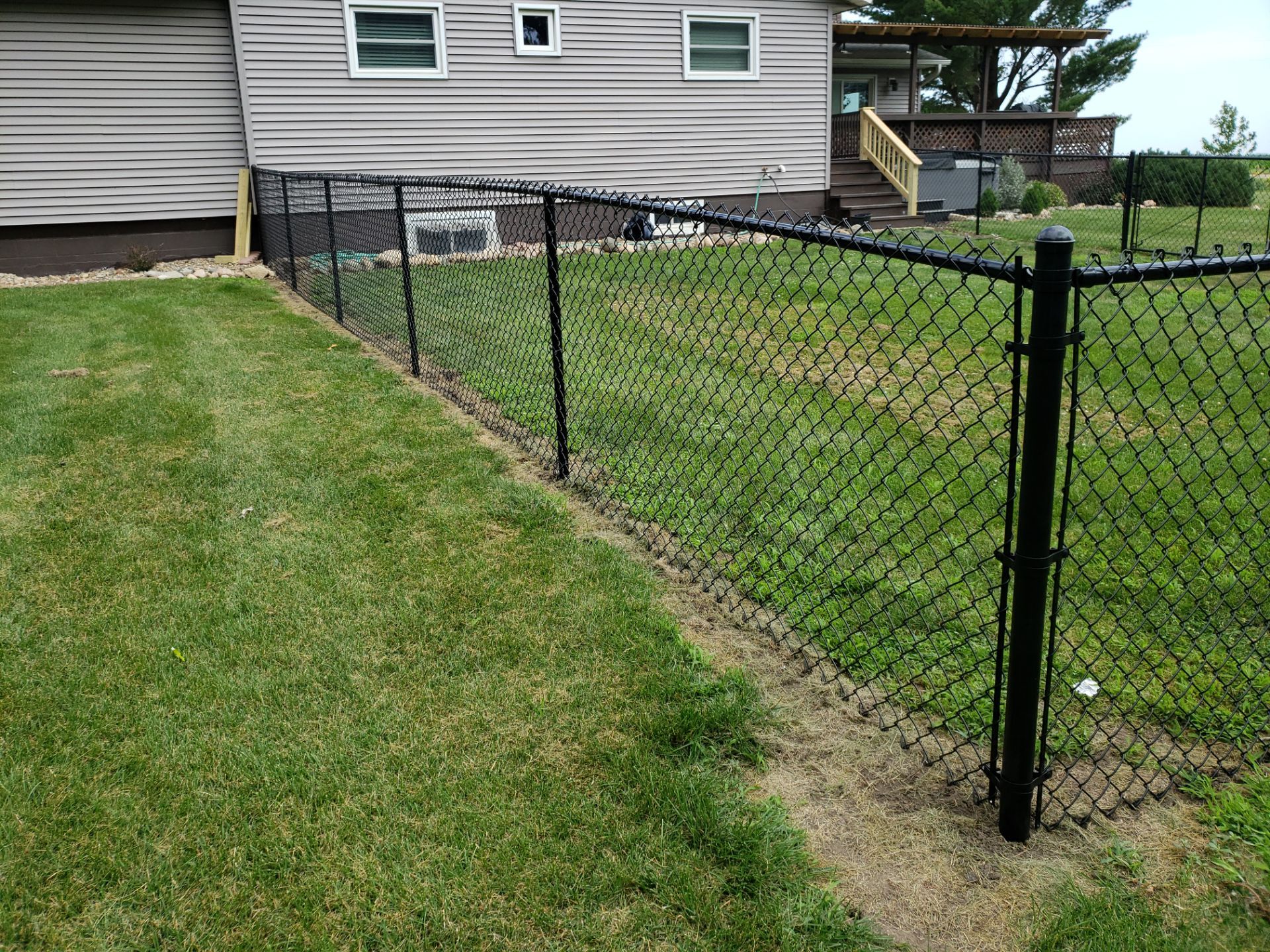Black Vinyl-Coated Chain Link Fence Installation in Fredericksburg by Perfect Picket Fence and Stain