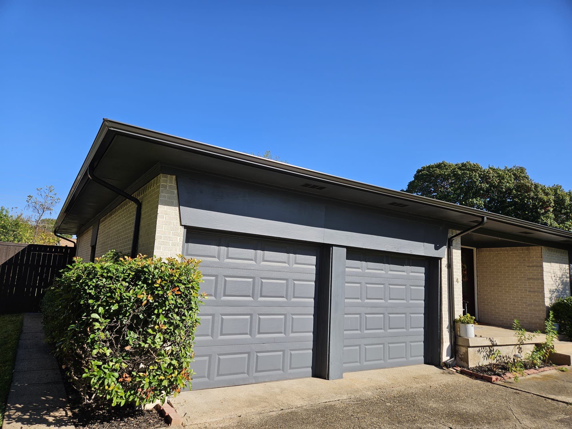 White brick/black accents with IKO Granite Black by Tejas Roofworks + Restoration