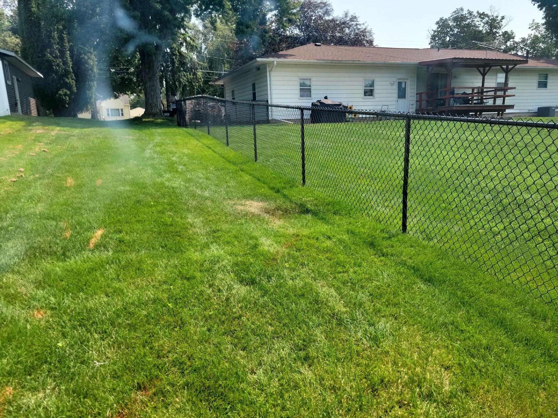 Black Vinyl-Coated Chain Link Fence Installation in New Hampton by Perfect Picket Fence and Stain