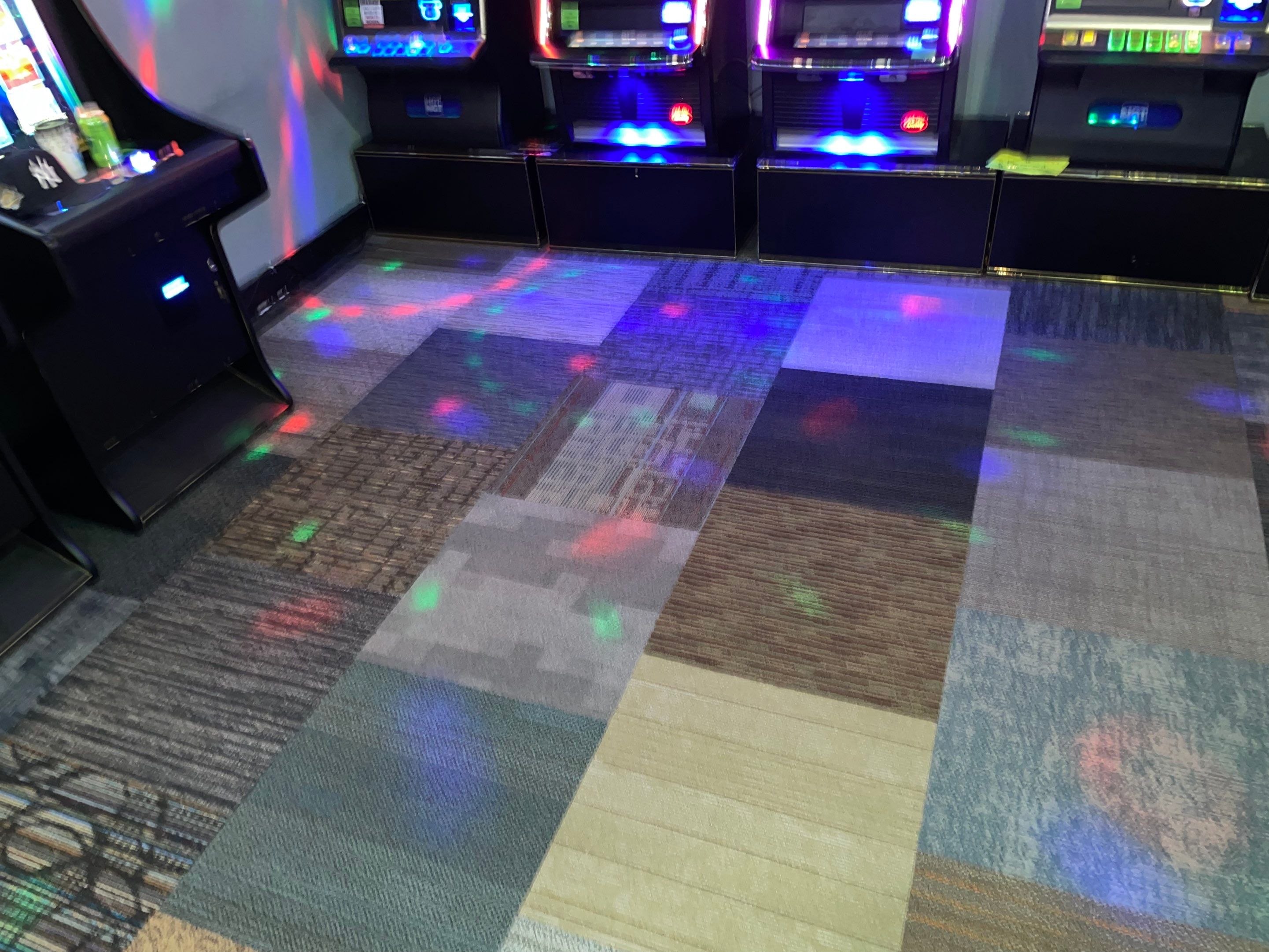 commercial carpet cleaning in an arcade or entertainment venue with patterned carpet between arcade machines