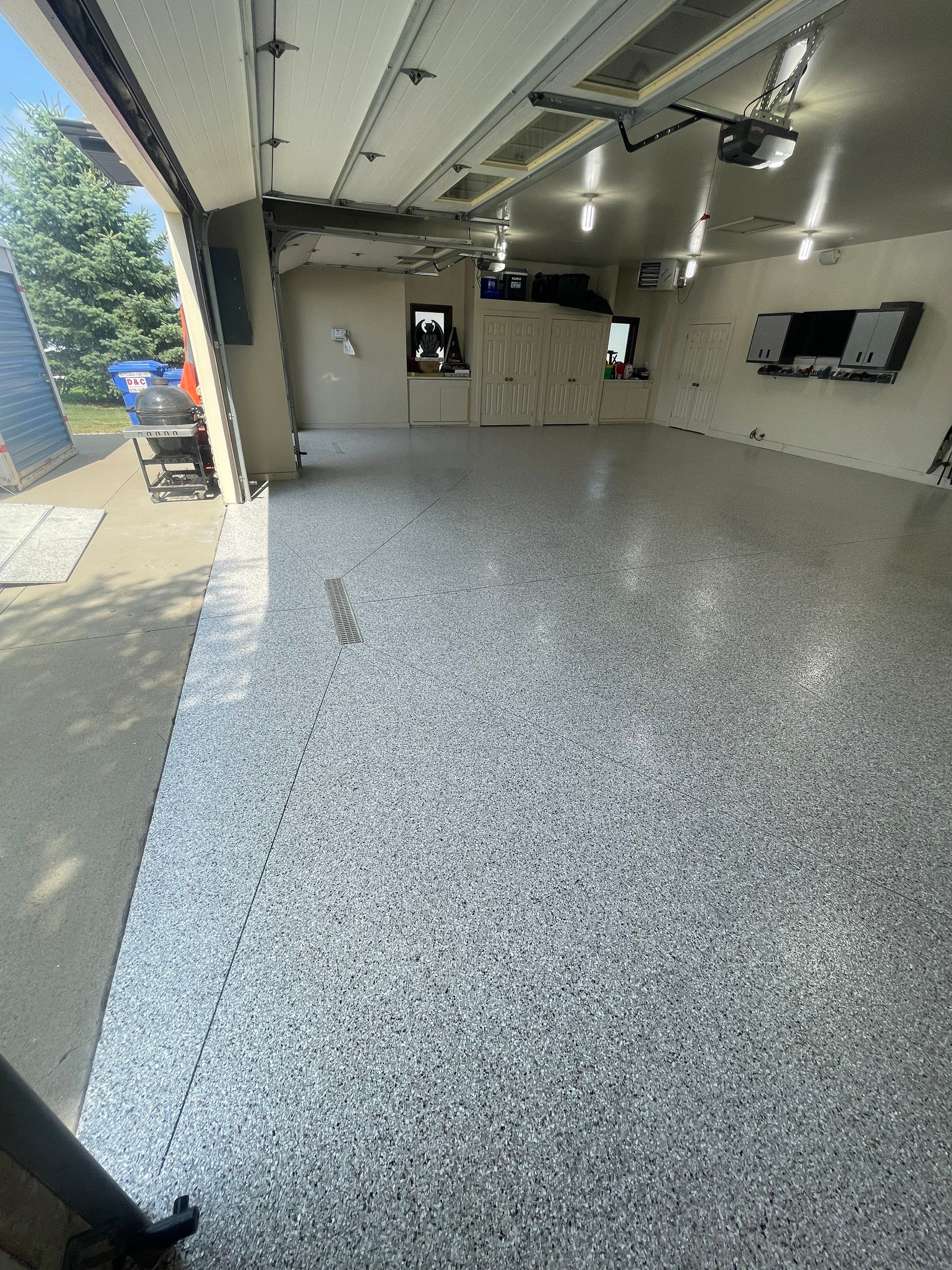 Coyote Flake Garage Floor Coating in Sioux Falls with Trench Drain by Select Painting, Coatings & Garage Cabinets