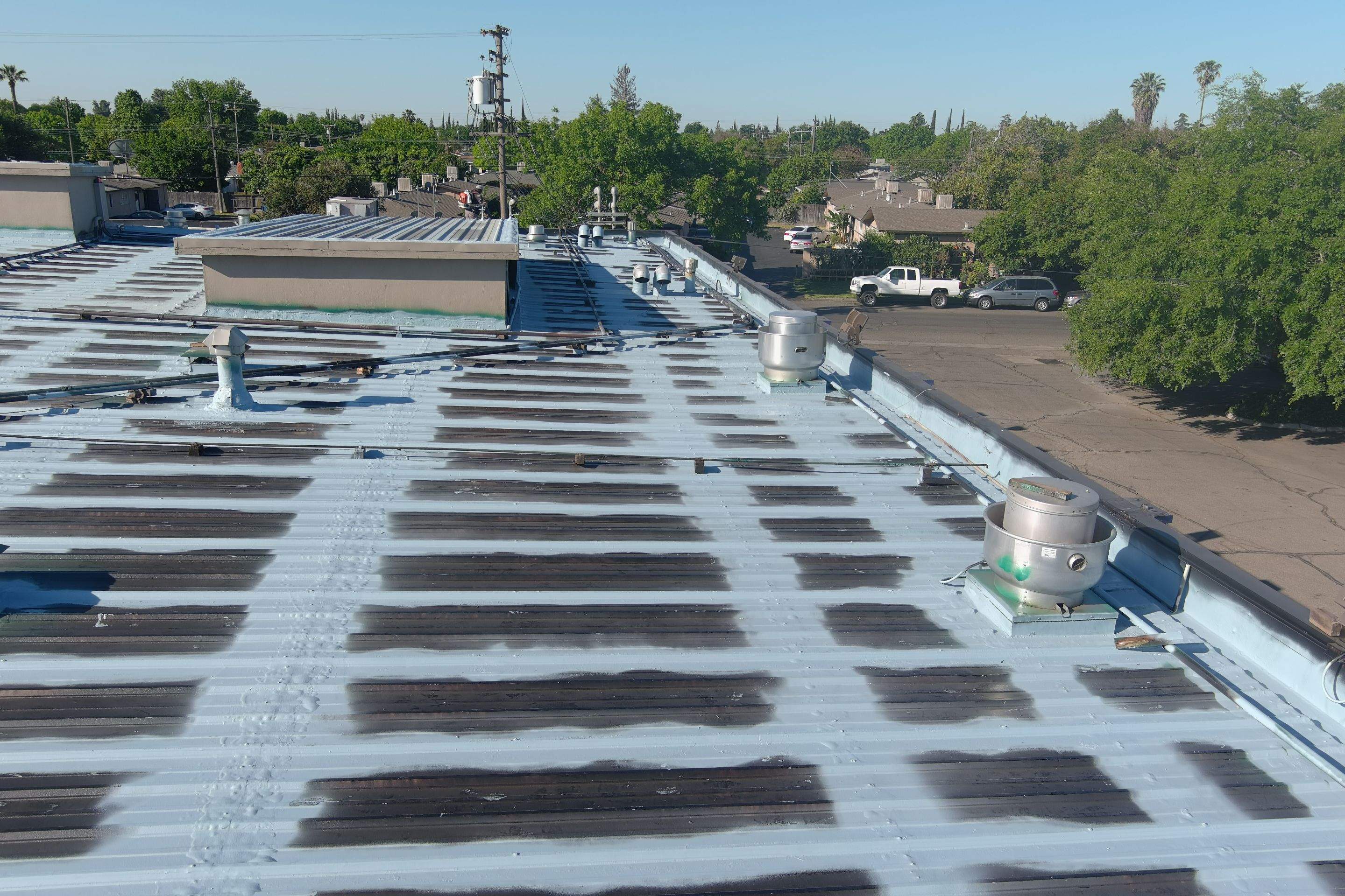 Metal roof restoration on commercial roof using Conklin Benchmark/ PUMA XL acrylic coatings over metal and foam by Straight Edge Roofing Inc
