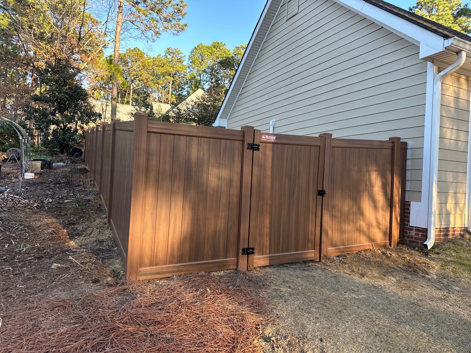 Mocha Walnut Wood-Grain Vinyl Privacy Fence Installation in Southern Pines by Superior Fence and Rail