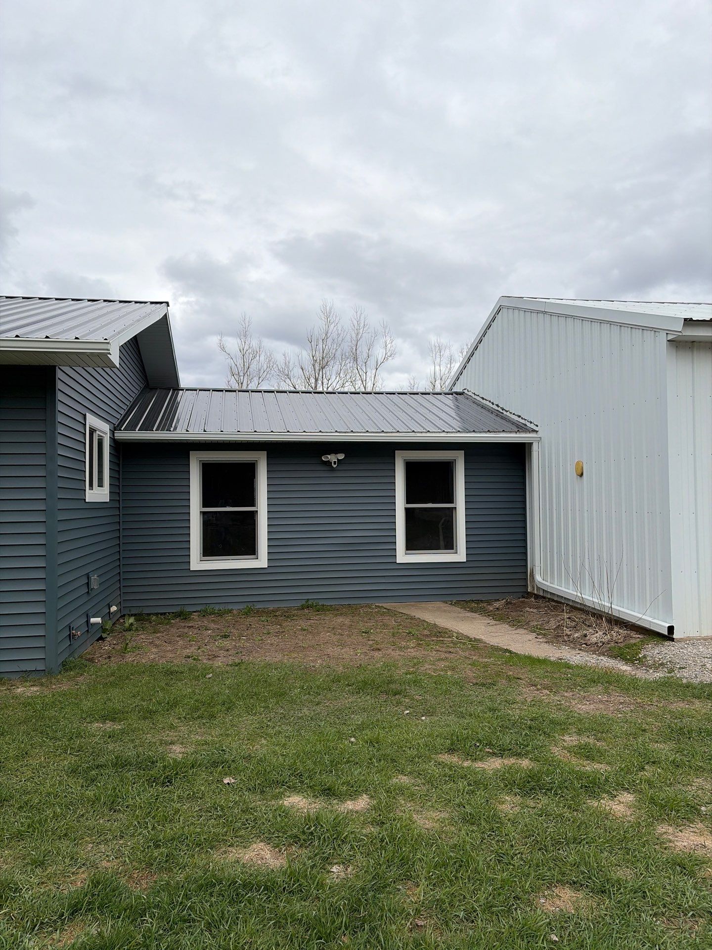White Gutter and Downspout Installation for Boyne Falls Residential Property by Rainbow Seamless Systems
