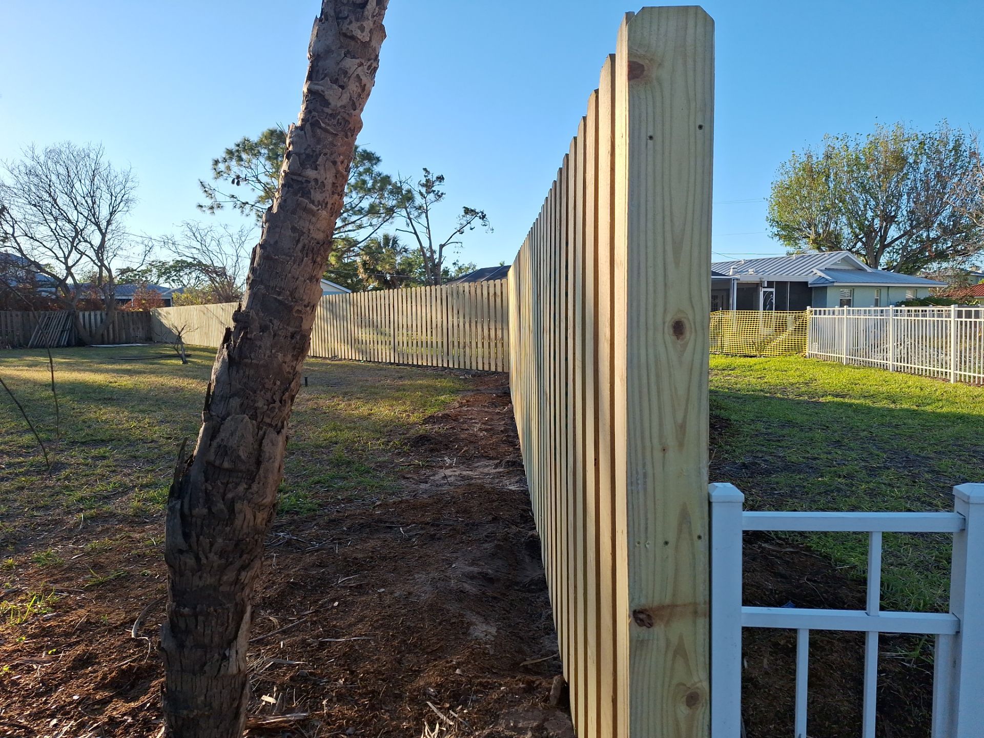 Wood Fence Installation using 6ft Pressure-Treated Wood Board-On-Board Privacy Fence with a 4Ft 3 Rail White Aluminum Fence by Asap fence and gates, LLC