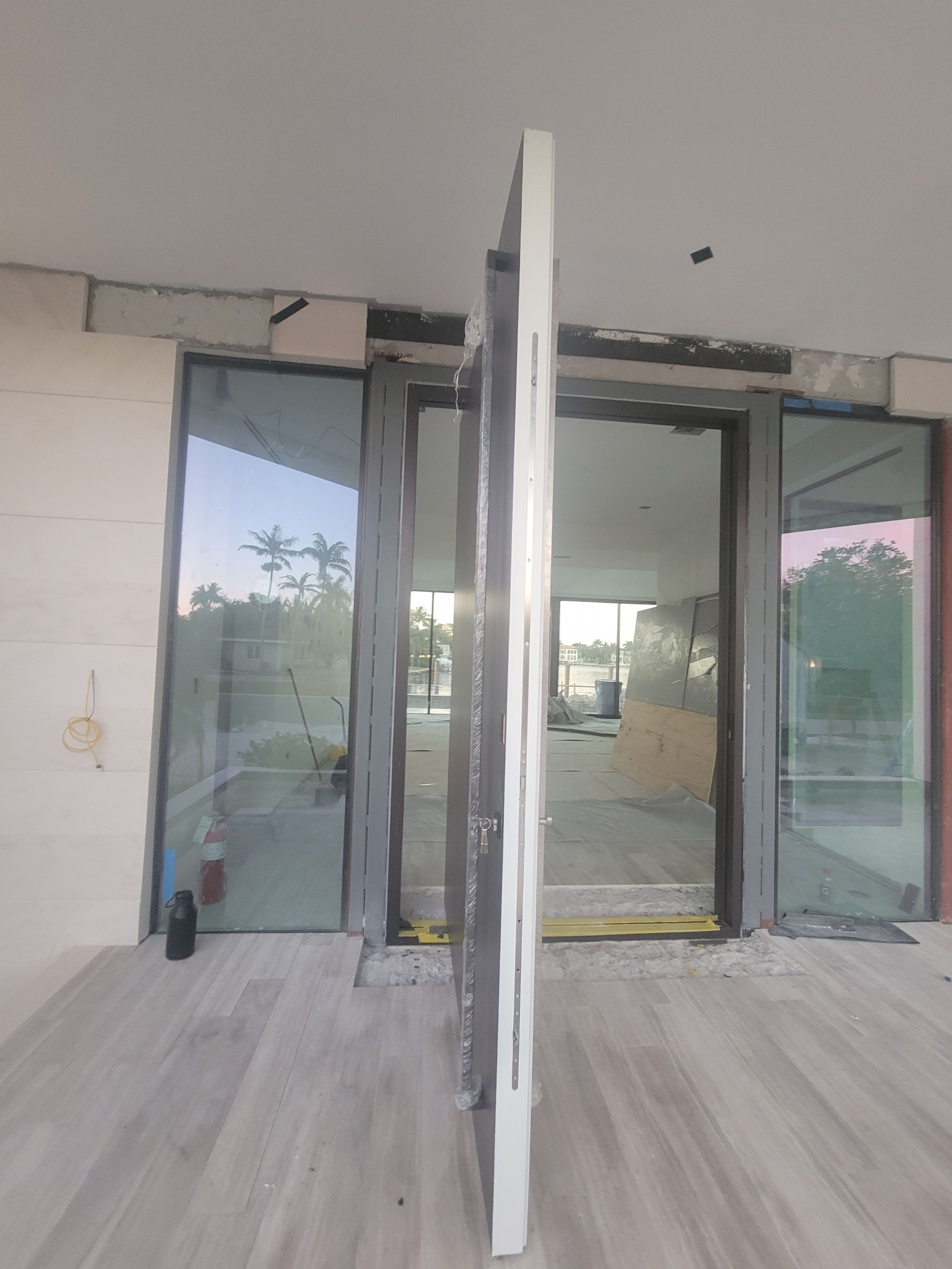 Custom Material Pivot Door installation by Impact Precious Wood Inc.