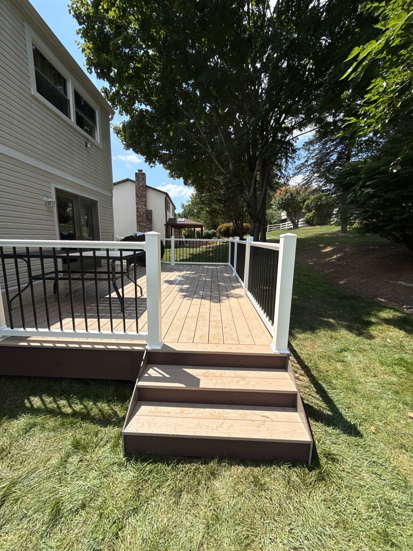 Bridgeville Composite Deck Build with White Railings and Versalok Retaining Wall by Cousins Roofing Siding & Decks