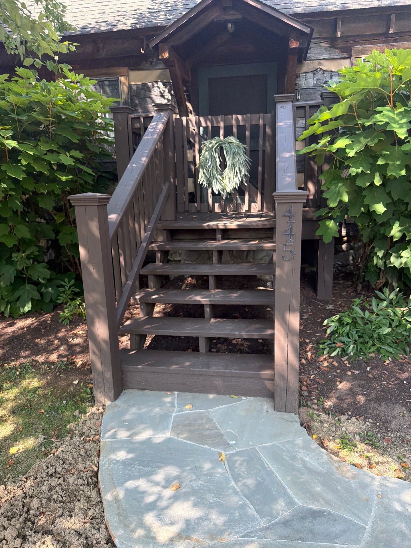 Custom Composite Deck with Stone Fireplace and Modern Cable Railing by Walnut Hollow Decks & Outdoor Living