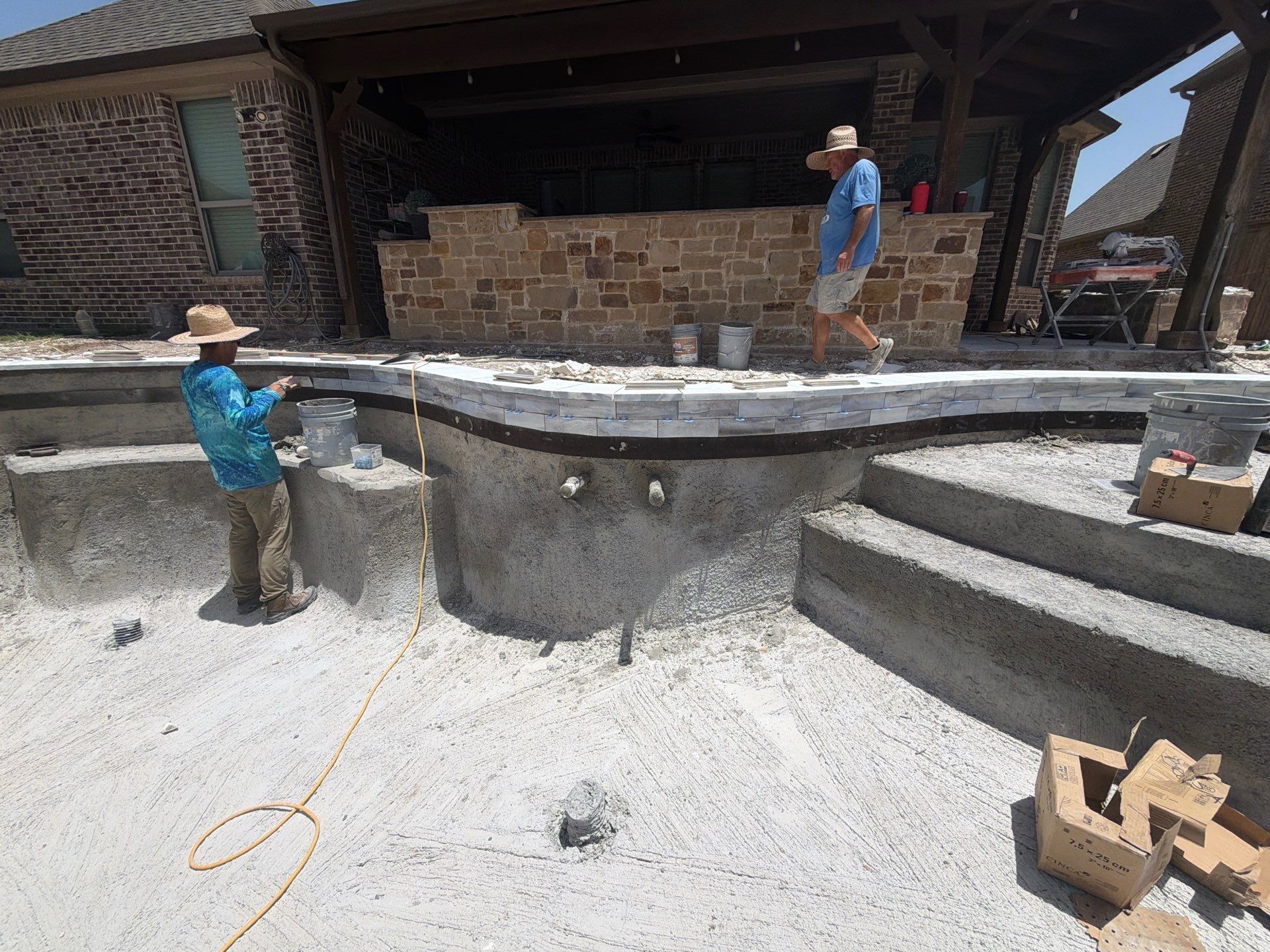 Freeform Pool with Tanning Ledge and Raised Stone Wall by Pinnacle Pools and Spas - DFW