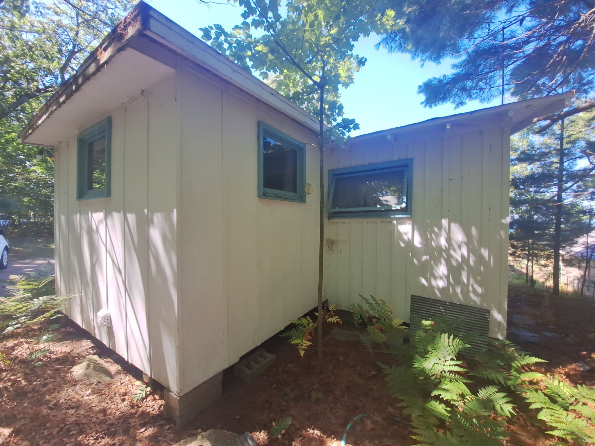 Lakeside Cottage Exterior Painting and Teal Trim Restoration in Mears by Gordon Painting