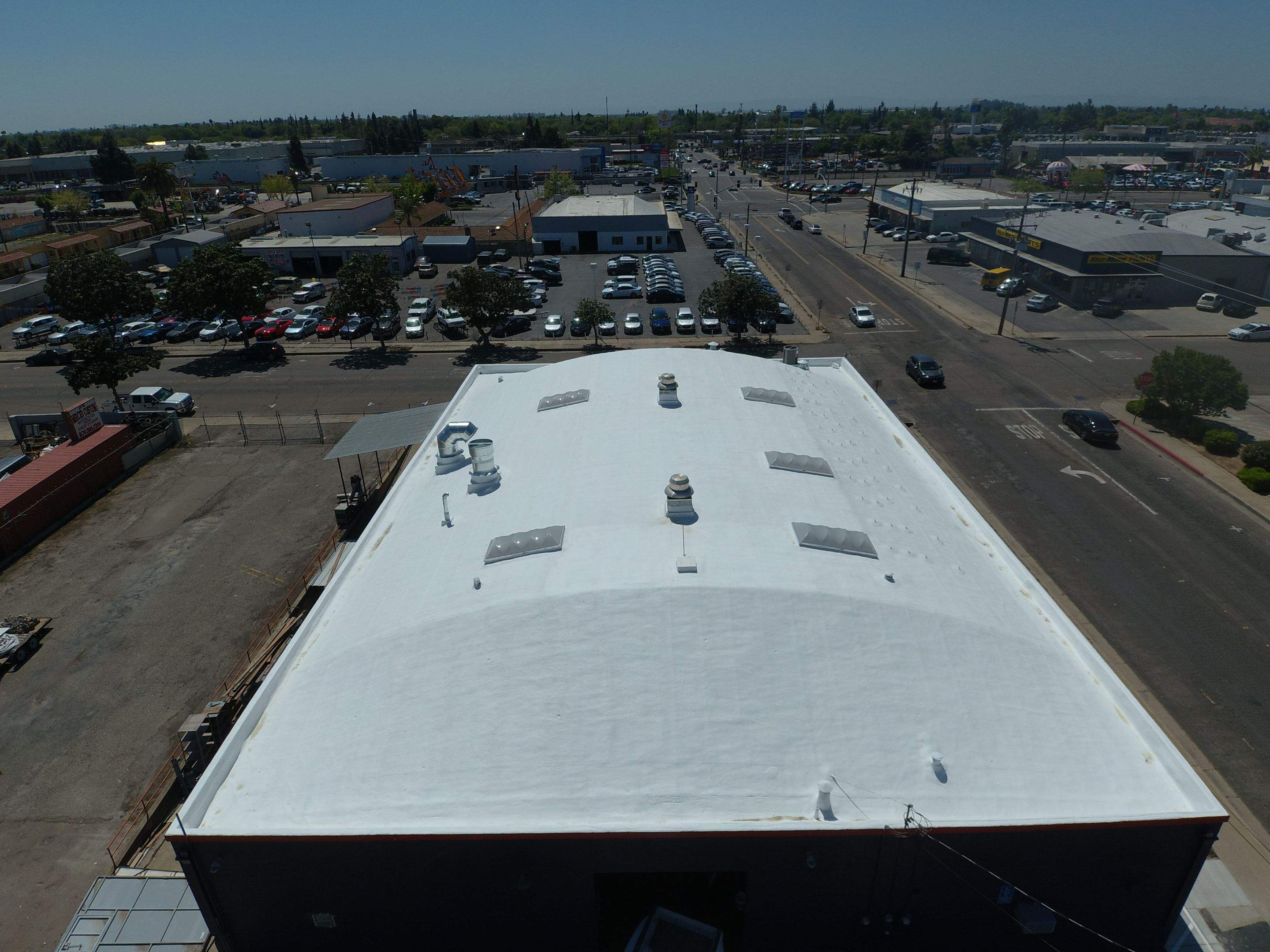Spray foam and coatings using Conklin Benchmark/PUMA XL coatings on Auto Body Shop by Straight Edge Roofing Inc