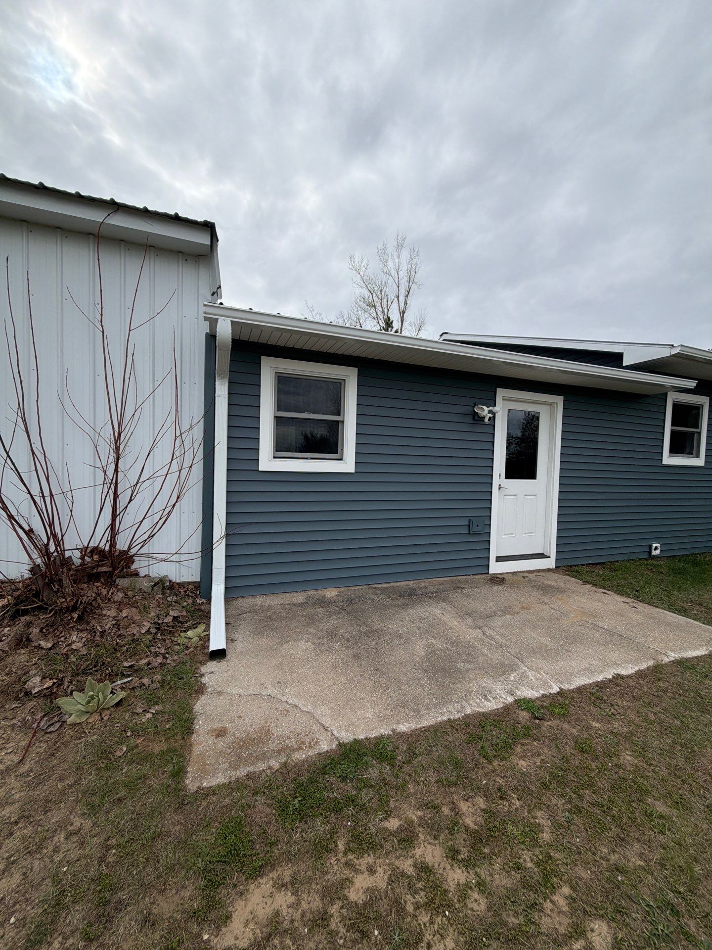 White Gutter and Downspout Installation for Boyne Falls Residential Property by Rainbow Seamless Systems