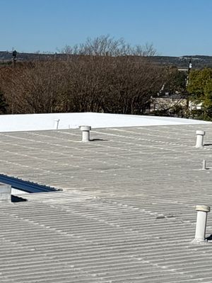 Metal roof surface meeting a flat roof membrane