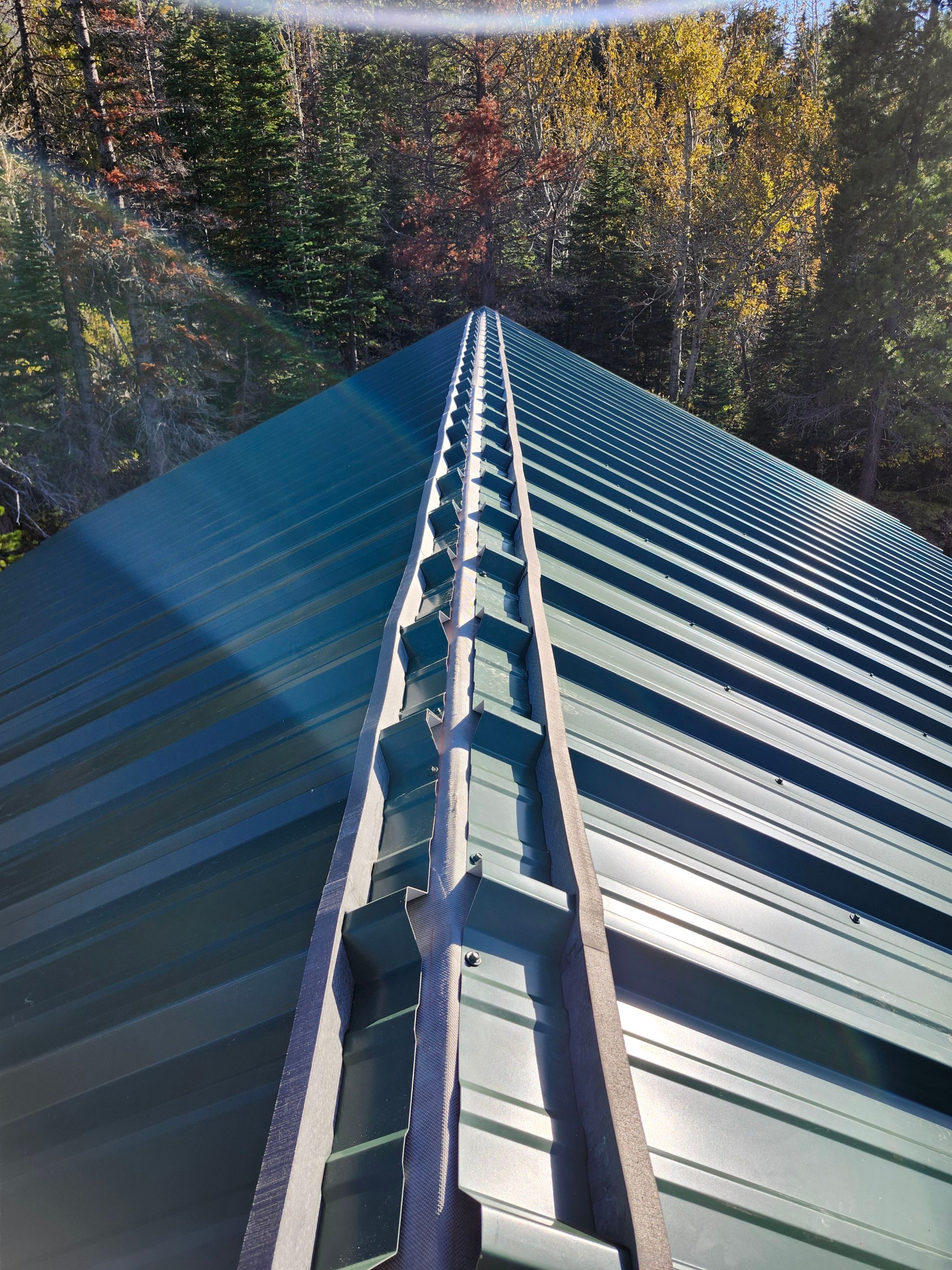 Green Standing Seam Metal Roof Installation in East Glacier Park by KQC Roofing