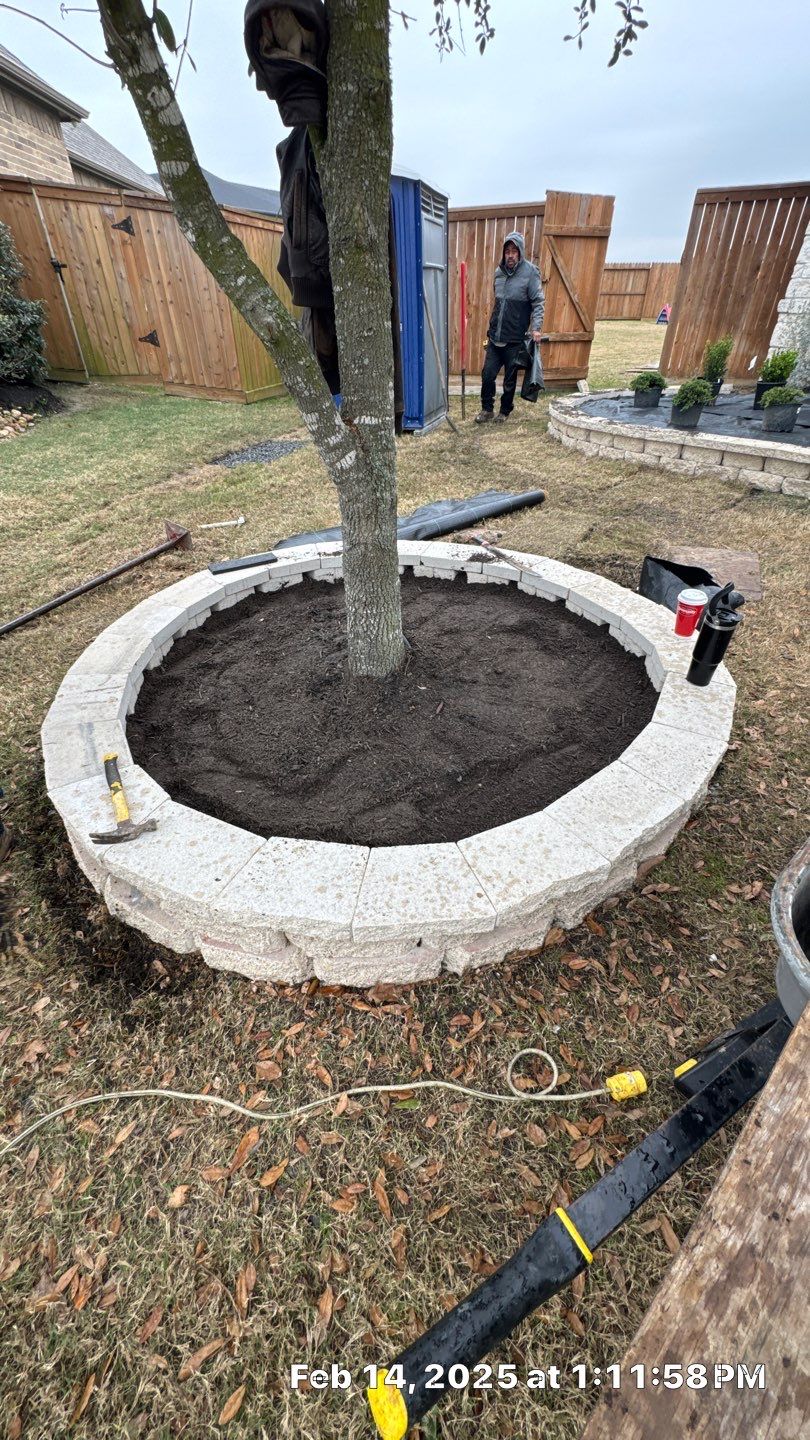 🌿✨ Darlene & Andrew’s Amazing Curb Appeal Transformation  Some projects are more than just landscaping—they’re a conversion of curb appeal from the ground up. For Darlene & Andrew, Alejandro and the Texas Urban Team designed and delivered a complete solution that reshaped their flower beds, solved drainage challenges, and gave new life to the sideyard.  💡 From planning to execution, every step was tailored to build both beauty and functionality:  🌸 Flower Beds, Reinvented  Demolition of old beds, plants, and mulch.  Fresh soil preparation, weed protection, and a brand-new retainer wall built with hand-cut stone and decorative caps.  Carefully selected plants and garden mix to ensure health and visual harmony.  💧 Drainage & Irrigation Upgrades  Outdated corrugated pipes replaced with PVC drainage lines to carry water safely away from the foundation.  New irrigation system combining drip lines and sprinklers—watering plants while keeping the house walls protected.  Sideyard drainage extended with catch basins and PVC piping to prevent water pooling and foundation stress.  🚶 Functional Sideyard with Walkway & Trash Area  Graded and leveled sideyard to manage runoff.  Installed a modern gravel and paver walkway for easy access.  Built a firm and tidy concrete-paver pad for trash containers—making the space both practical and polished.  🛠️ Stonework & Craftsmanship  Every stone in the retainer wall was cut, set, and secured by the team of handcrafters, ensuring a durable build that doubles as a design statement.  ✅ Outcome: Darlene & Andrew’s property now has better drainage, a clean and organized sideyard, and elegant new flower beds—all designed for long-term durability and lasting beauty.  📢 Before hiring anyone, review our portfolio. Our work speaks louder than words—each project is a blend of function, protection, and design crafted to last. by Texas Urban Elements