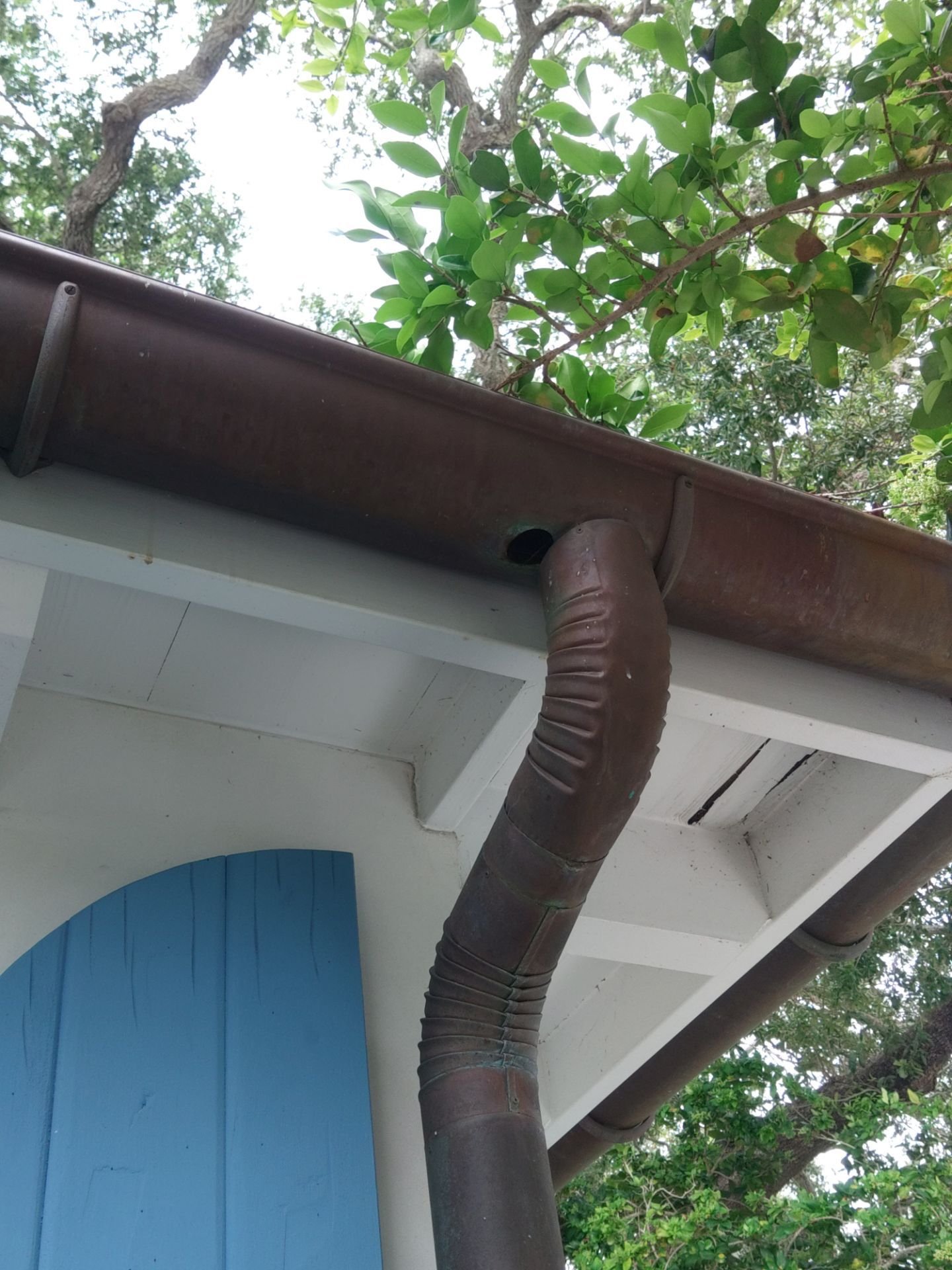 Seamless aluminum gutter installation in Sarasota, FL using 3x4 elbow downspouts combined with round downspouts by Gutter Professors