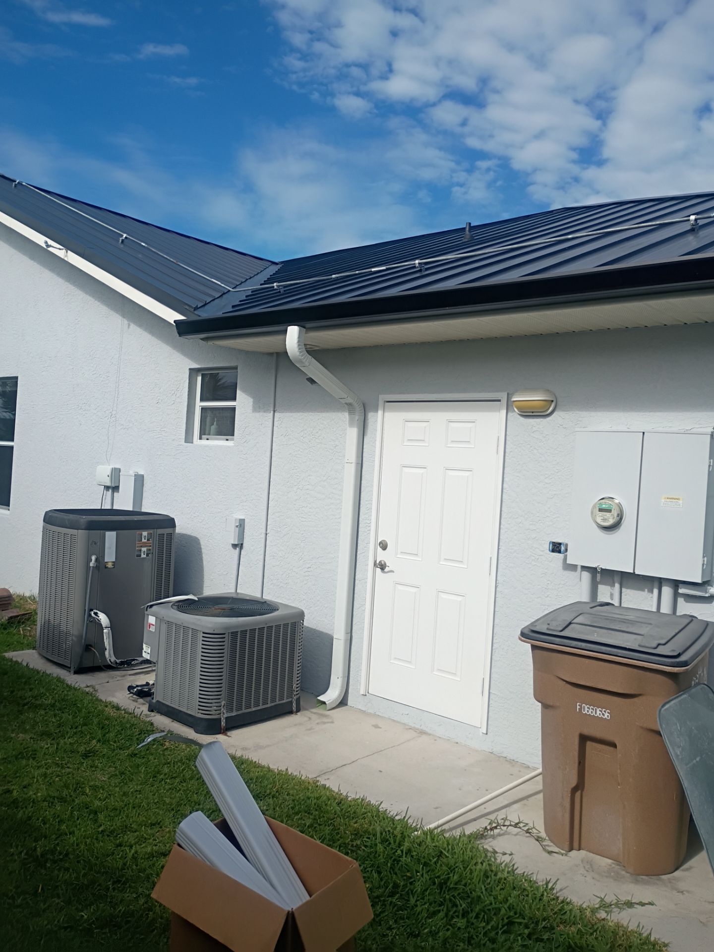 Black Seamless Gutters and White Downspouts in Cape Coral FL by Gutter Professors