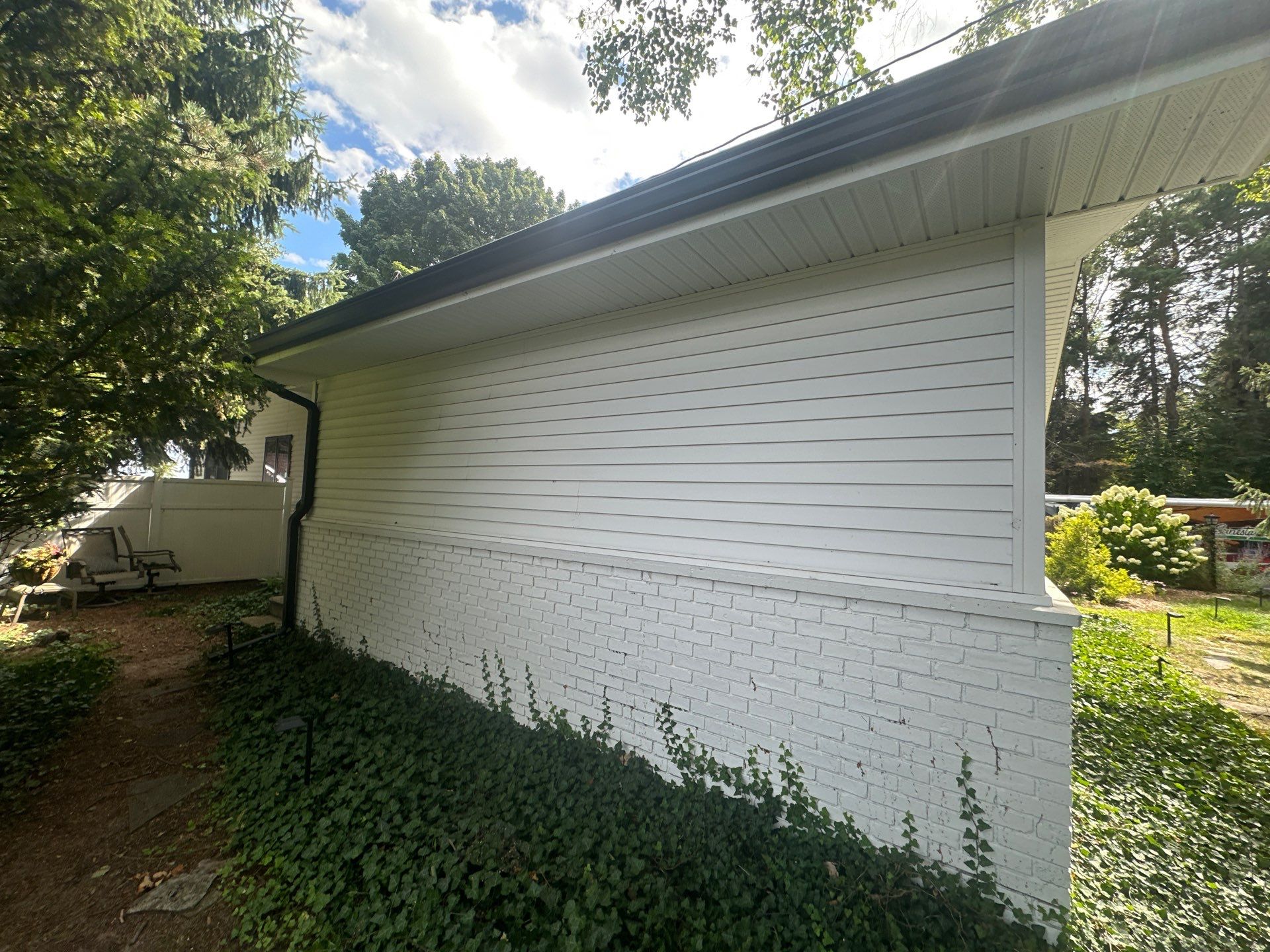 Black Gutter and Gutter Helmet Installation for Suttons Bay Home by Rainbow Seamless Systems