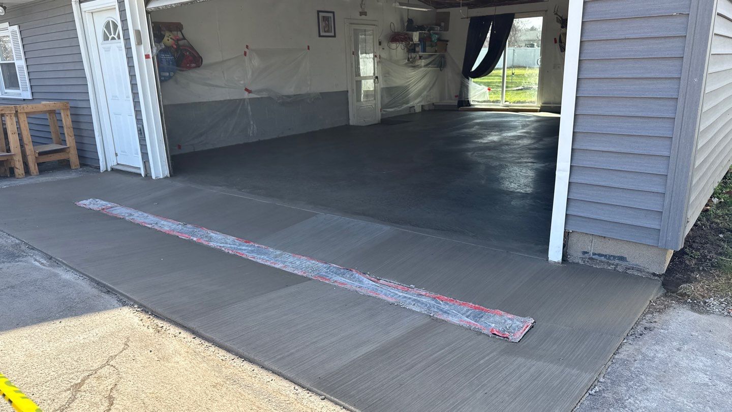 Concrete garage floor replacement with a broom finished apron and drain  by NG Masonry & Construction LLC