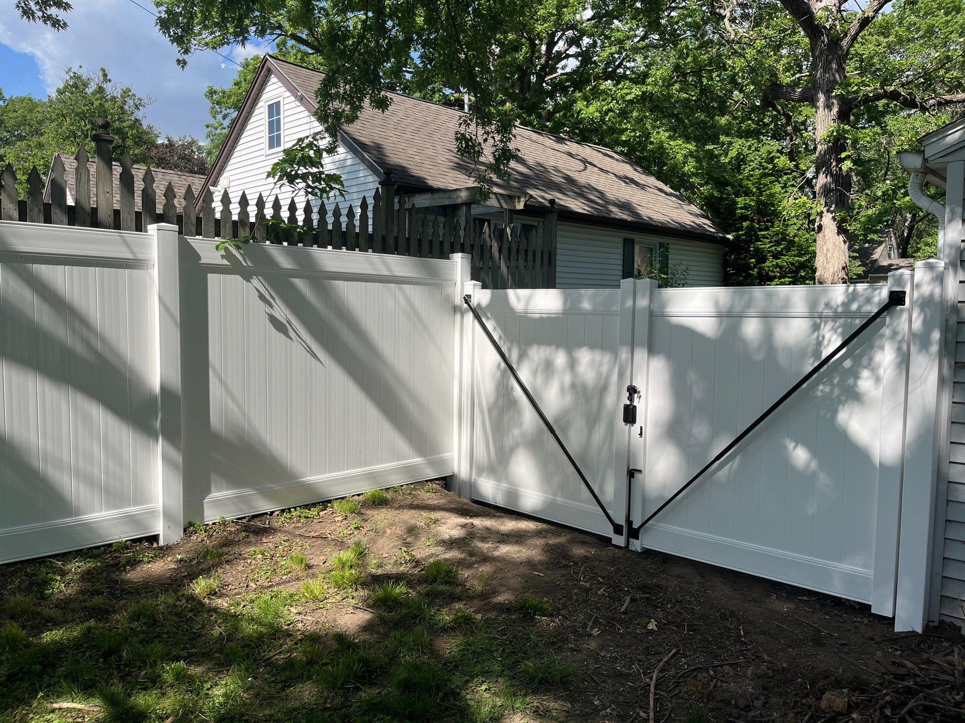 White Vinyl Privacy Fence and Double Gate Installation in Cedar Falls by Perfect Picket Fence and Stain