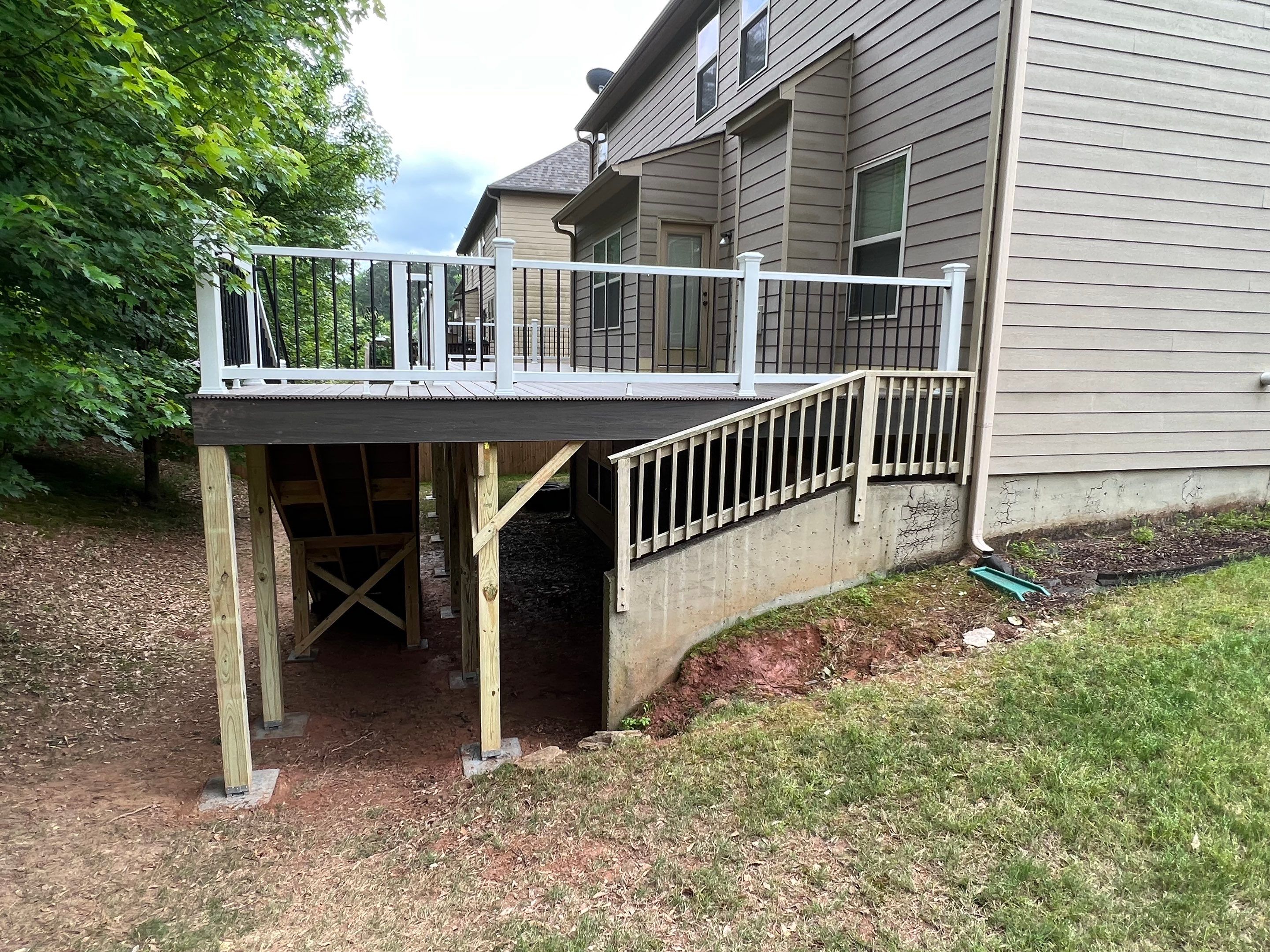 Custom Elevated Deck Replacement with White and Black Railings by Swift Home Renovations