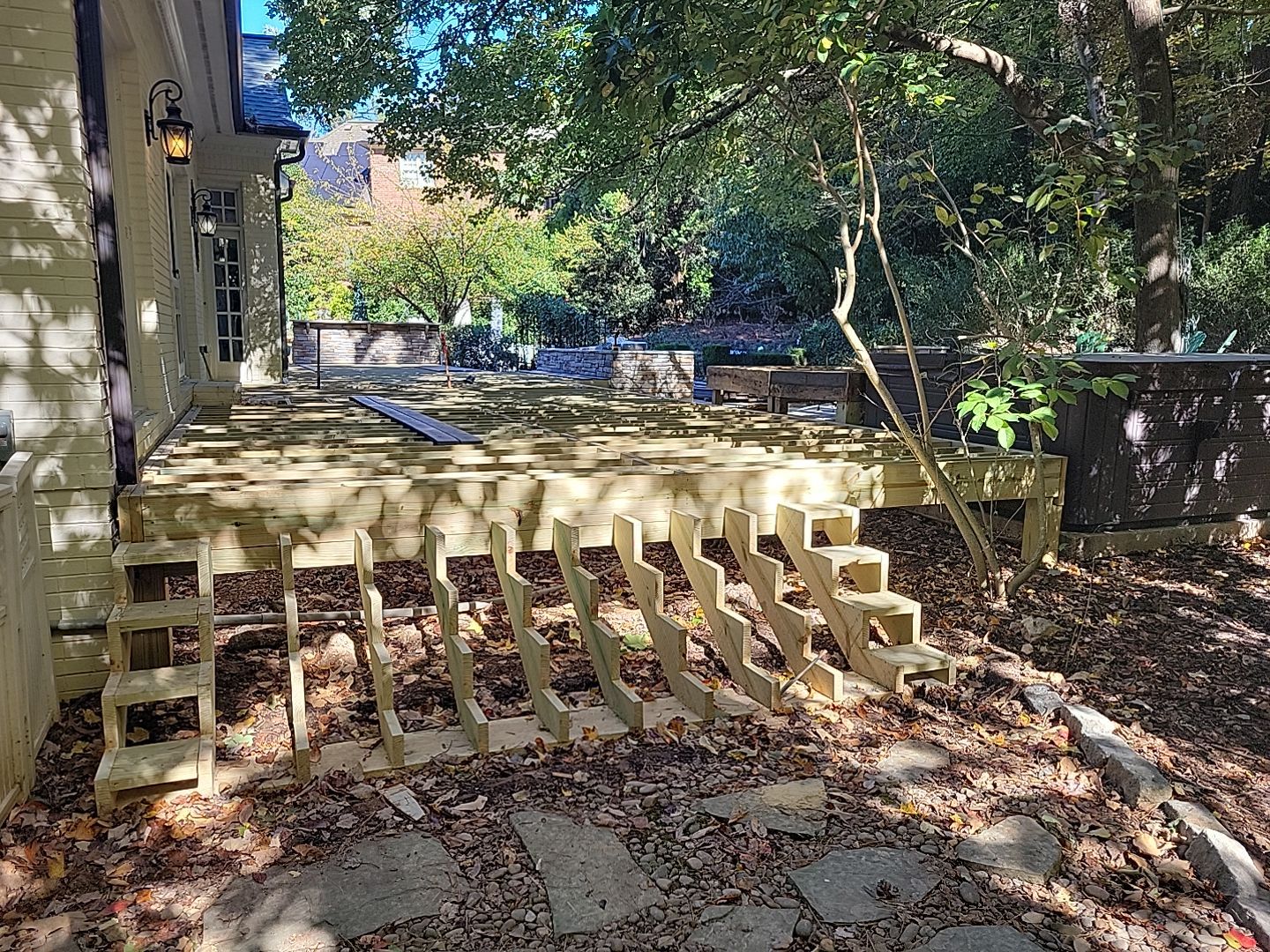 New Deck, Stone Fountain Feature, Circle Stone Sitting Area with Fireplace by The Remodeling Company
