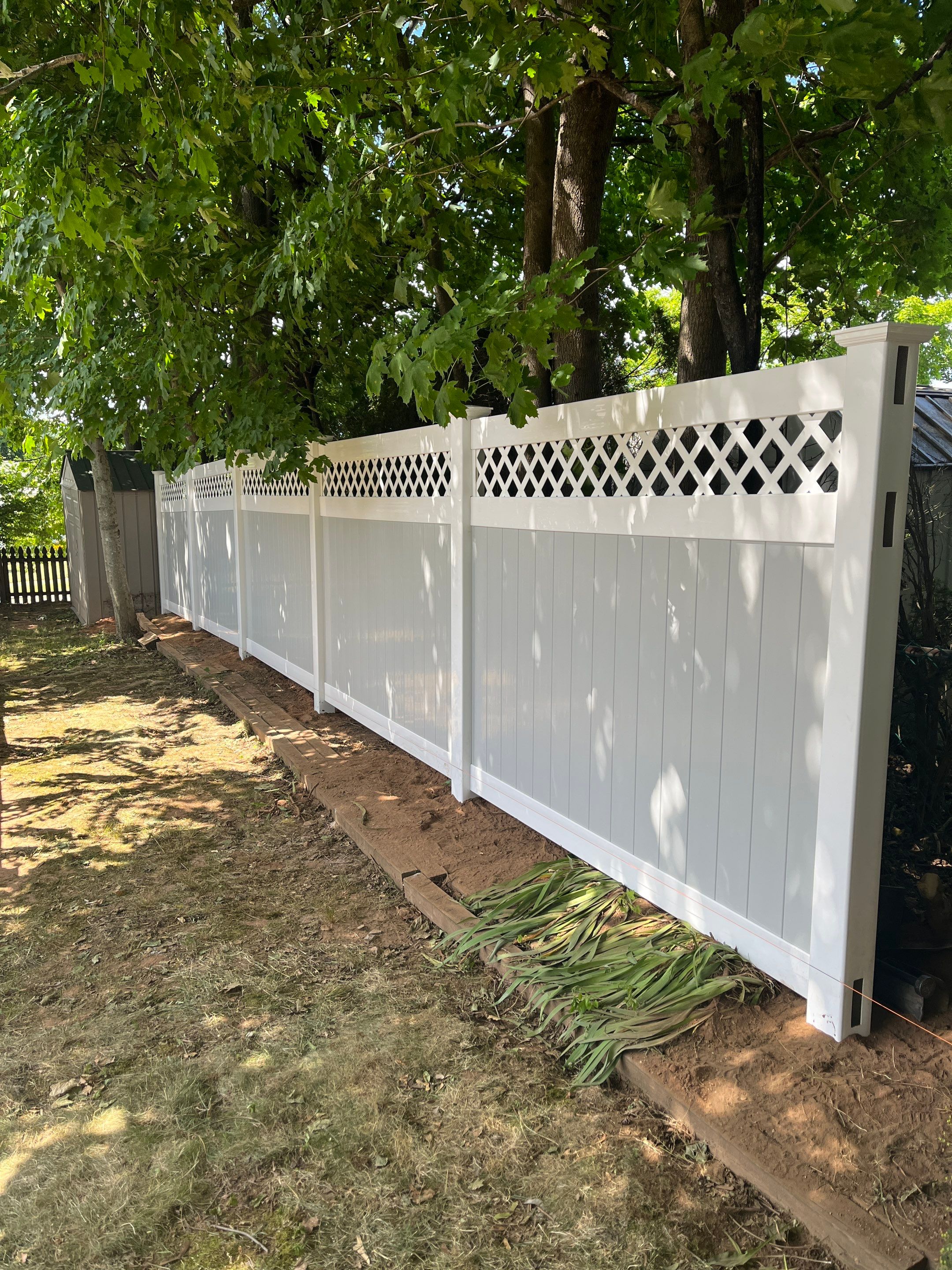Vinyl privacy fence, Decorative lattice top. Two toned coloring White and Gray by DiGiorgi Roofing and Siding Inc