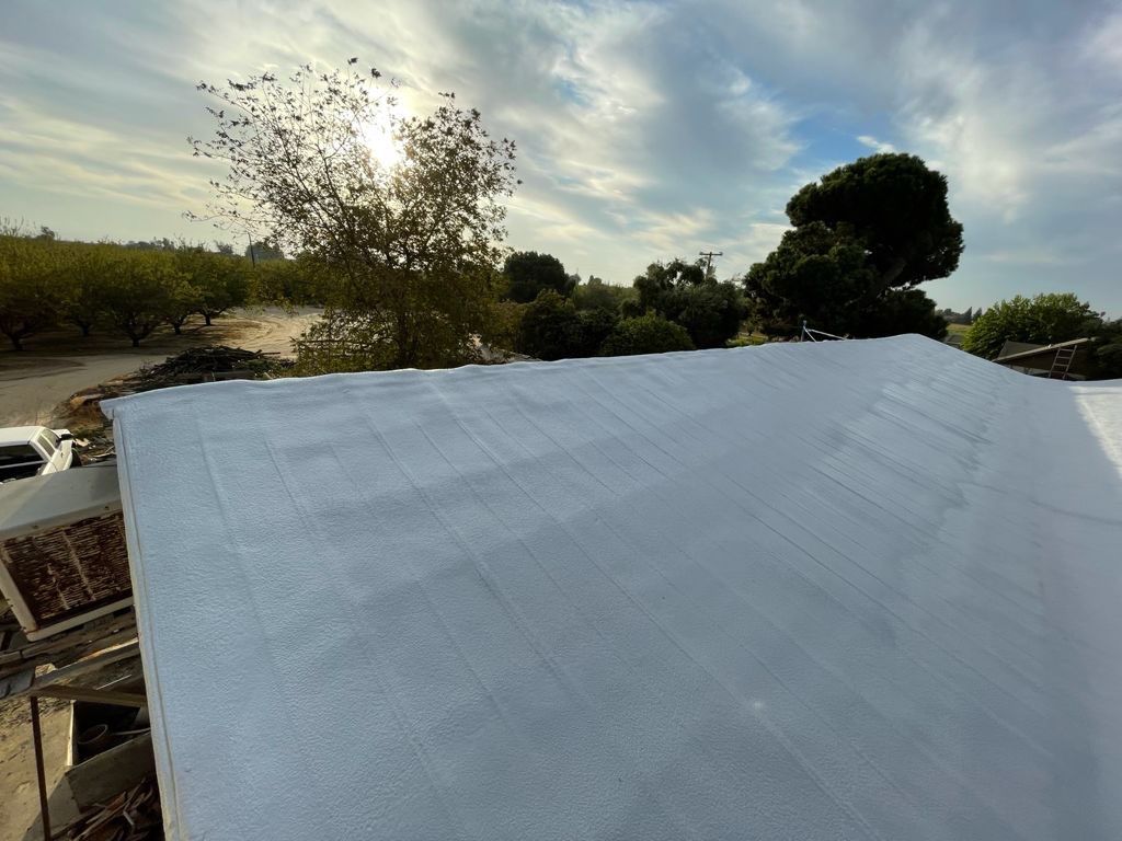 Metal roof sprayed with polyurethane spray foam and coatings by Straight Edge Roofing Inc