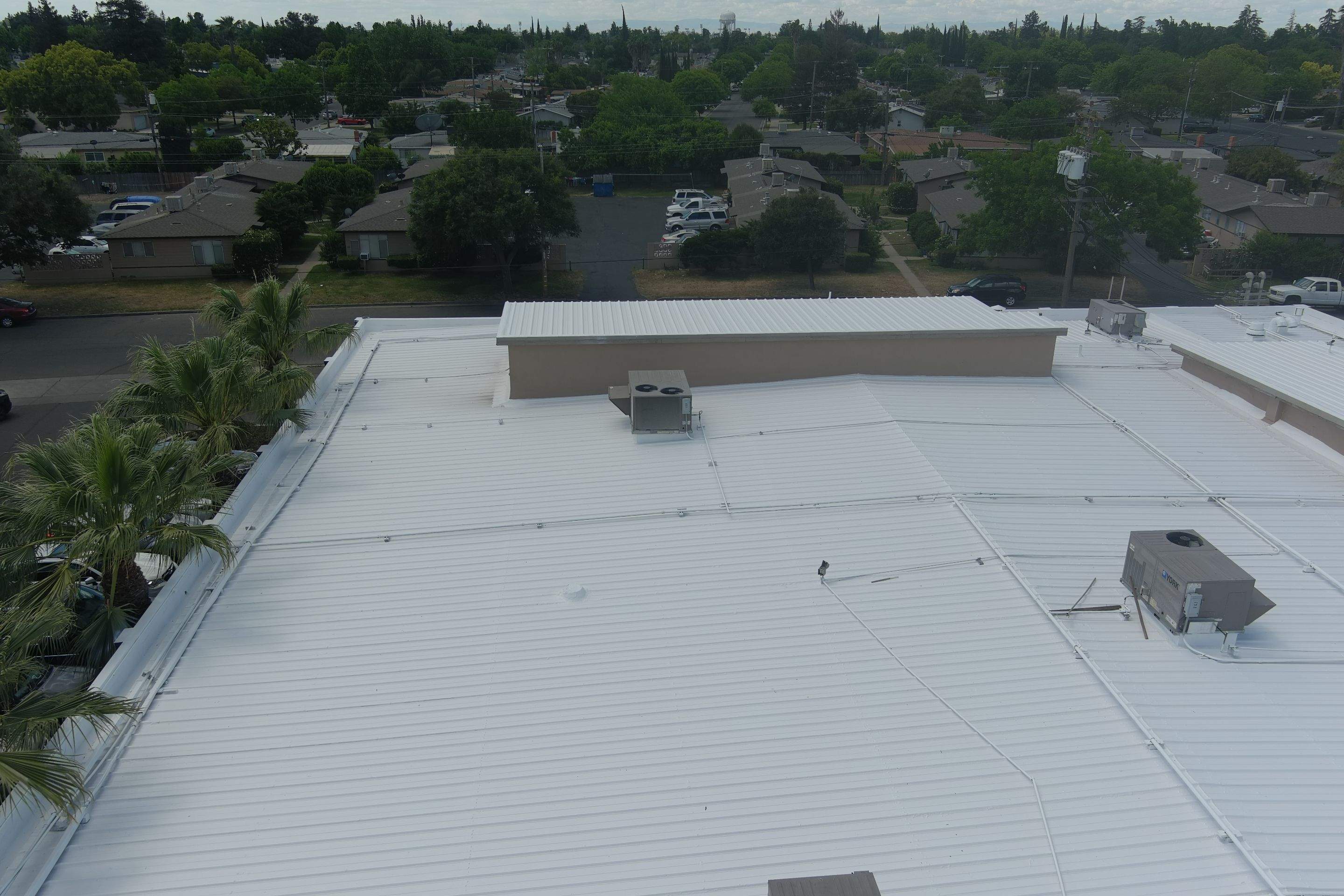 Metal roof restoration on commercial roof using Conklin Benchmark/ PUMA XL acrylic coatings over metal and foam by Straight Edge Roofing Inc