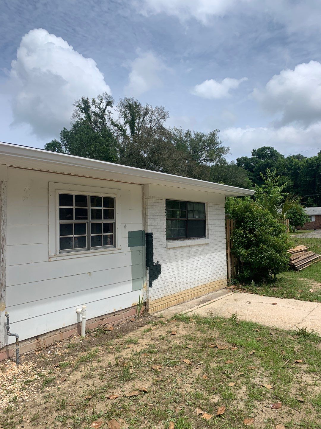 White Seamless Gutters and Black Downspouts by Gutter Professors